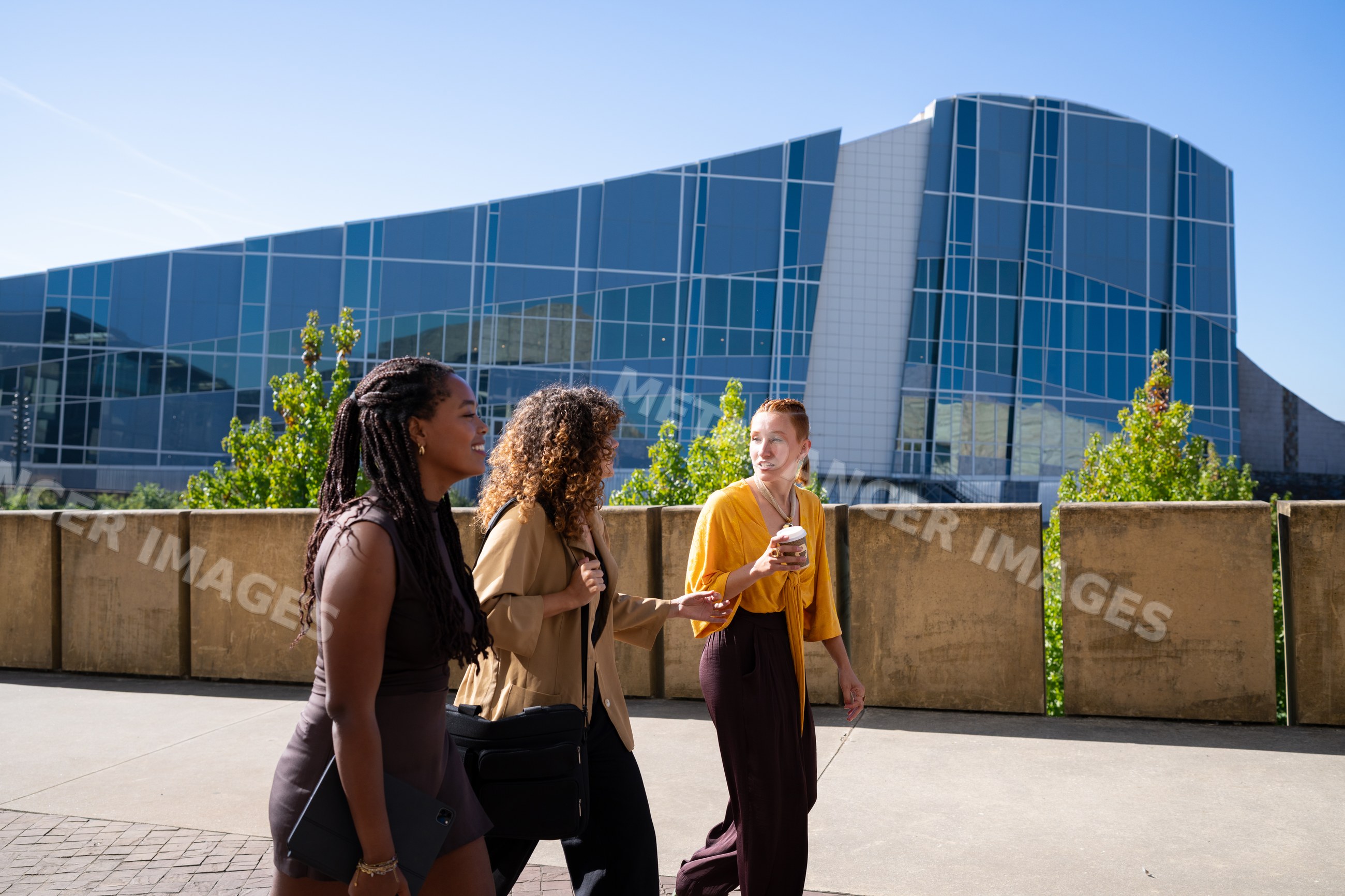Three African American and white women walking and talking