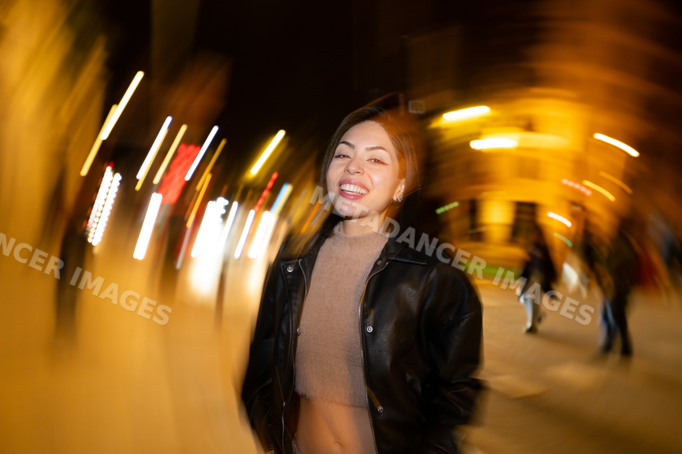 Hispanic woman smiling on city street at night
