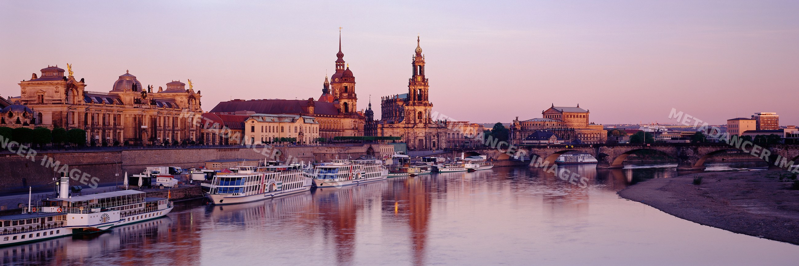 Dresden skyline with historic buildings along the elbe river at sunset