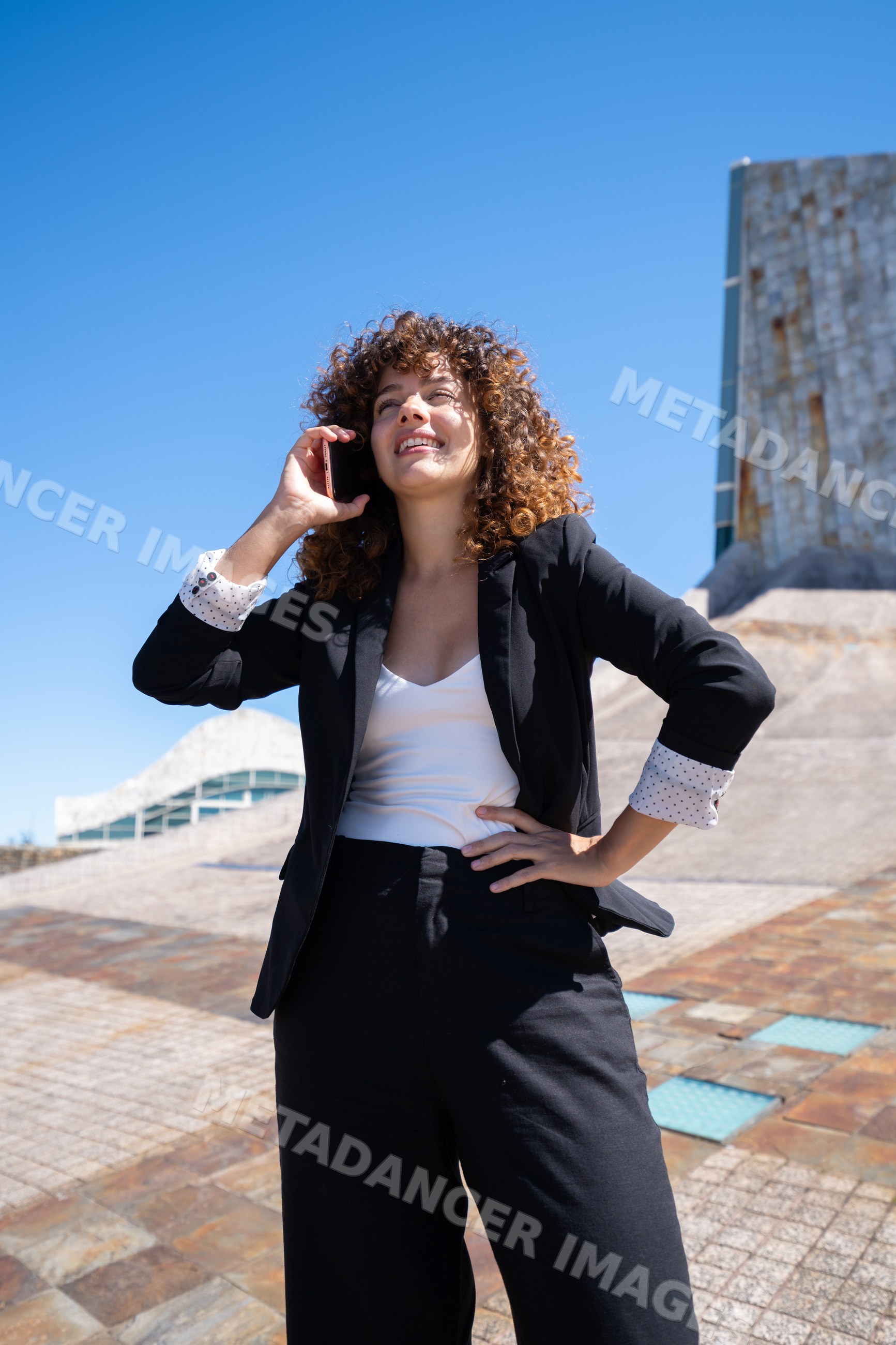 Businesswoman talking on phone outdoors near modern architecture