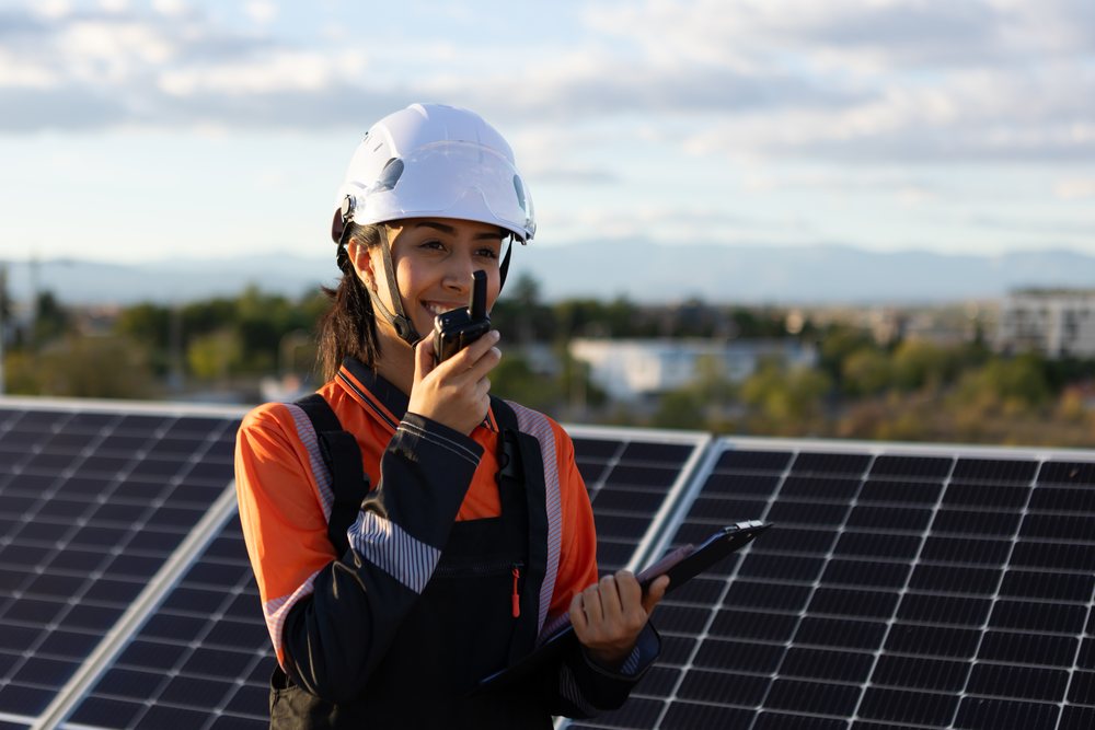 Hispanic woman engineer uses walkie talkie