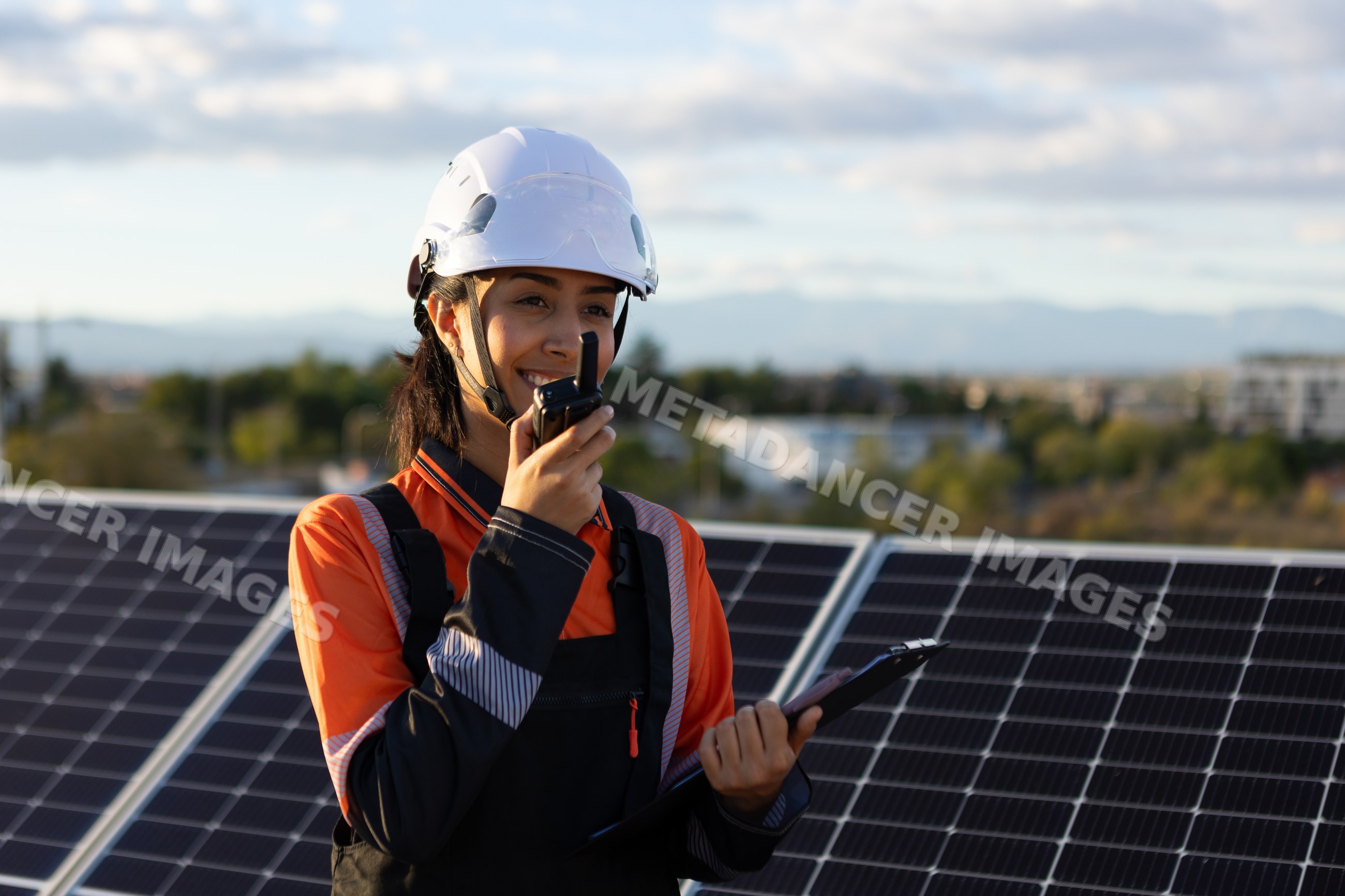 Hispanic woman engineer uses walkie talkie