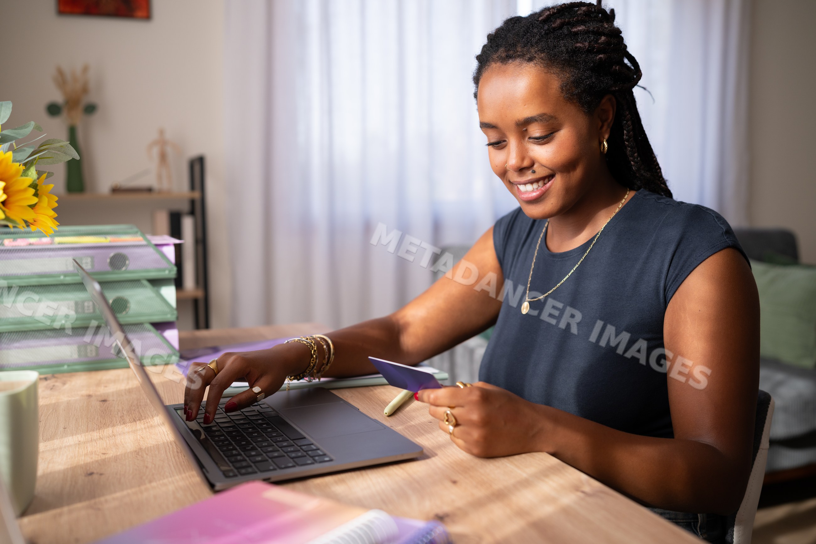 African American woman shops online using a credit card