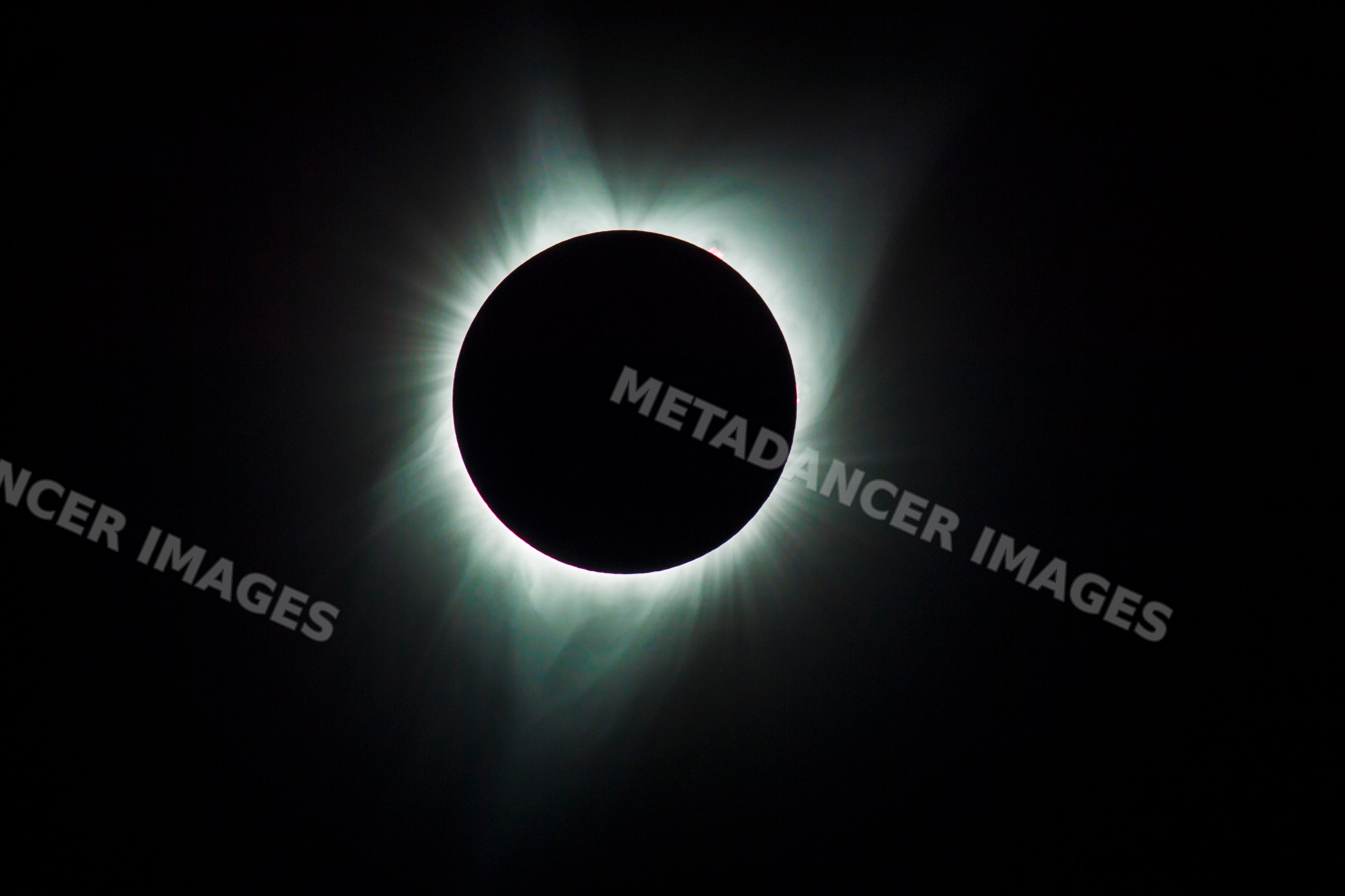 Total solar eclipse with glowing corona in dark sky