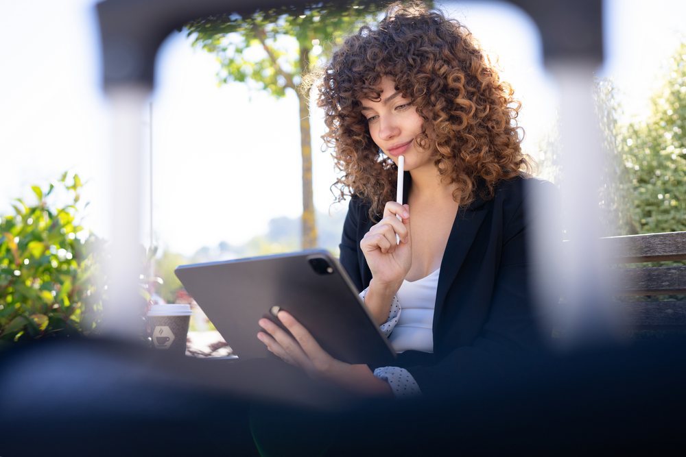 White woman using tablet with digital pen