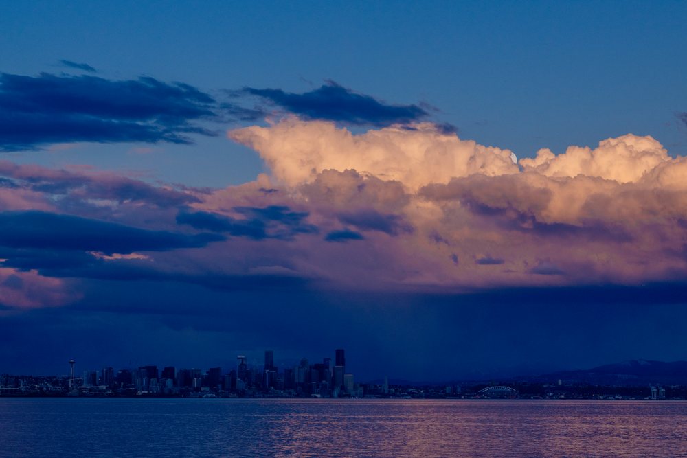 Seattle skyline at sunset with dramatic storm clouds over water