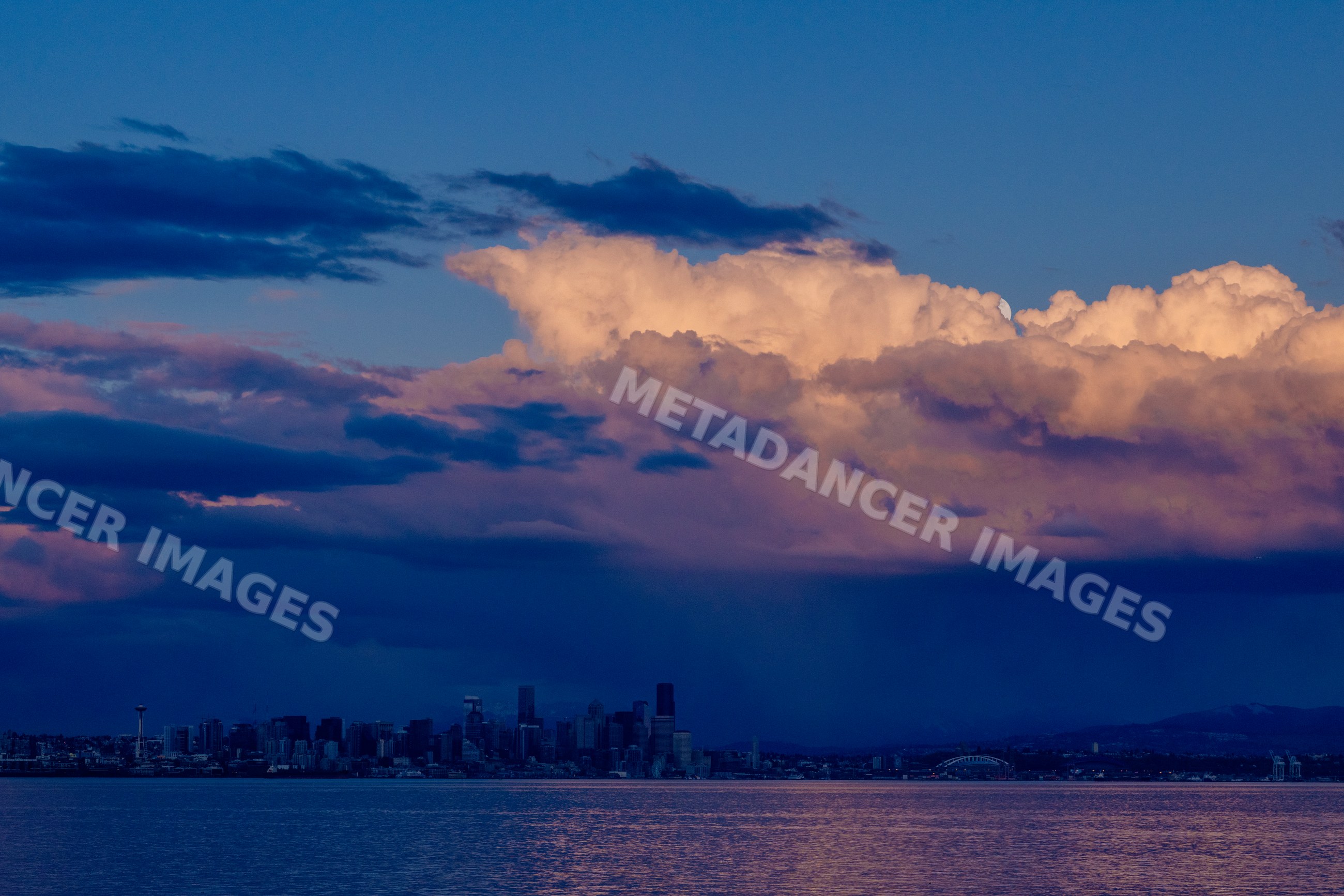 Seattle skyline at sunset with dramatic storm clouds over water
