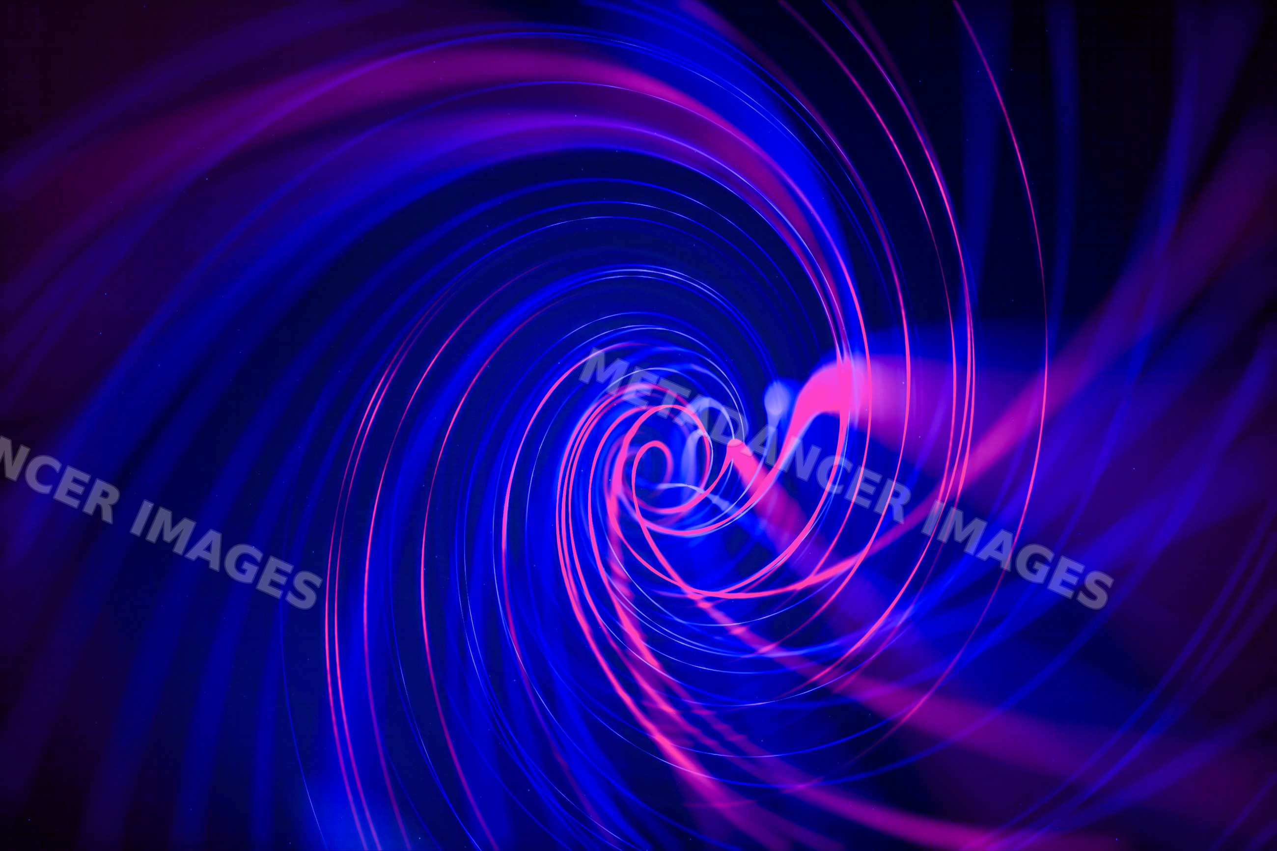 Abstract swirling vortex of blue and pink light trails on dark