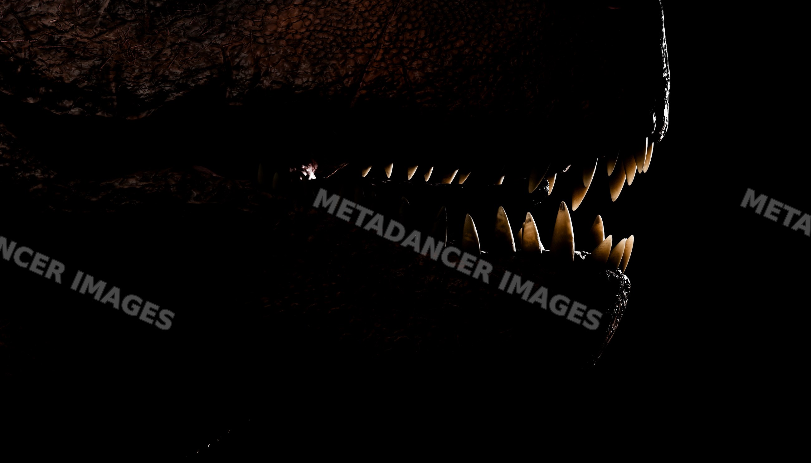 Close-up of a T-Rex mouth showing sharp teeth in dark lighting