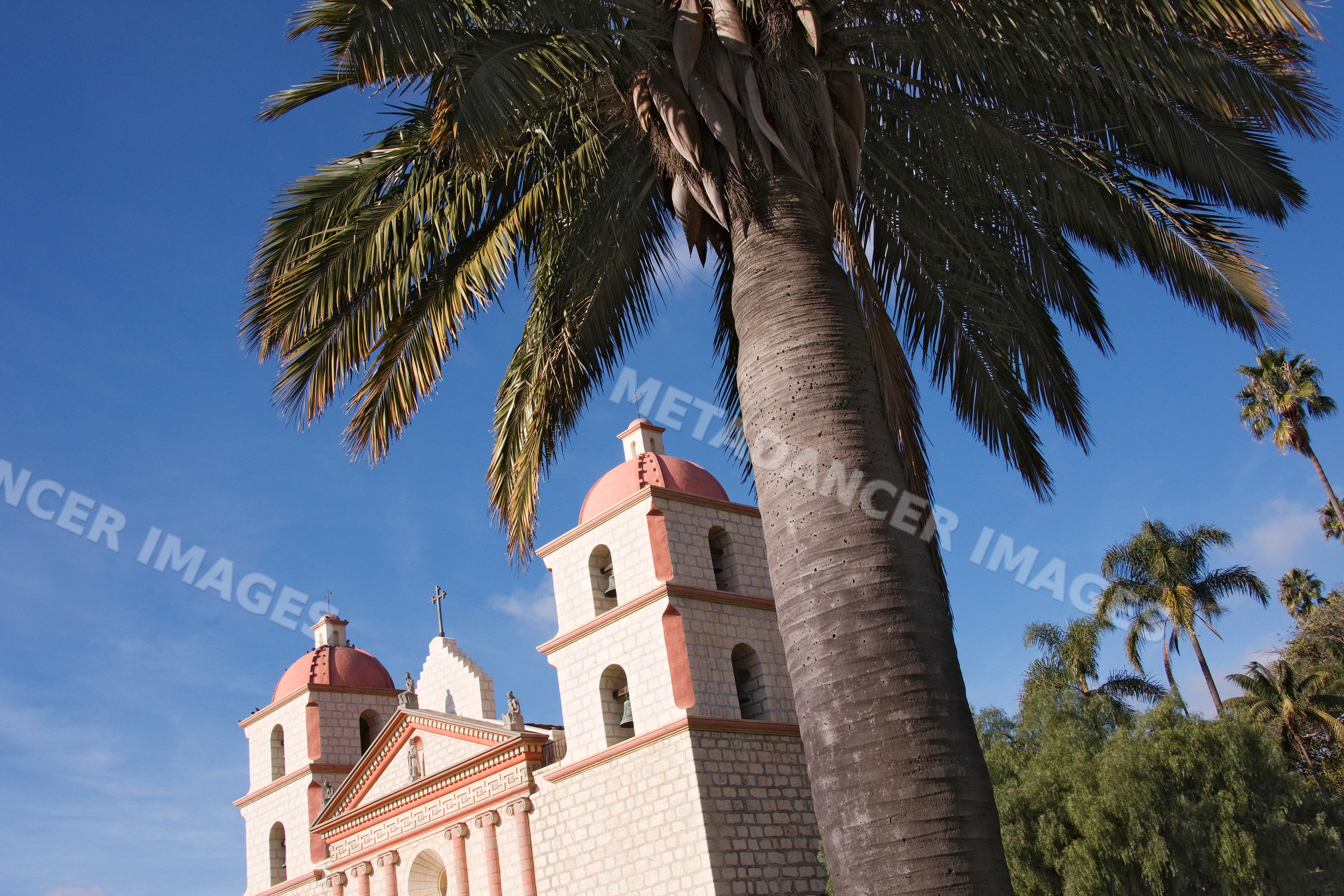 Santa barbara mission church with palm trees under blue sky