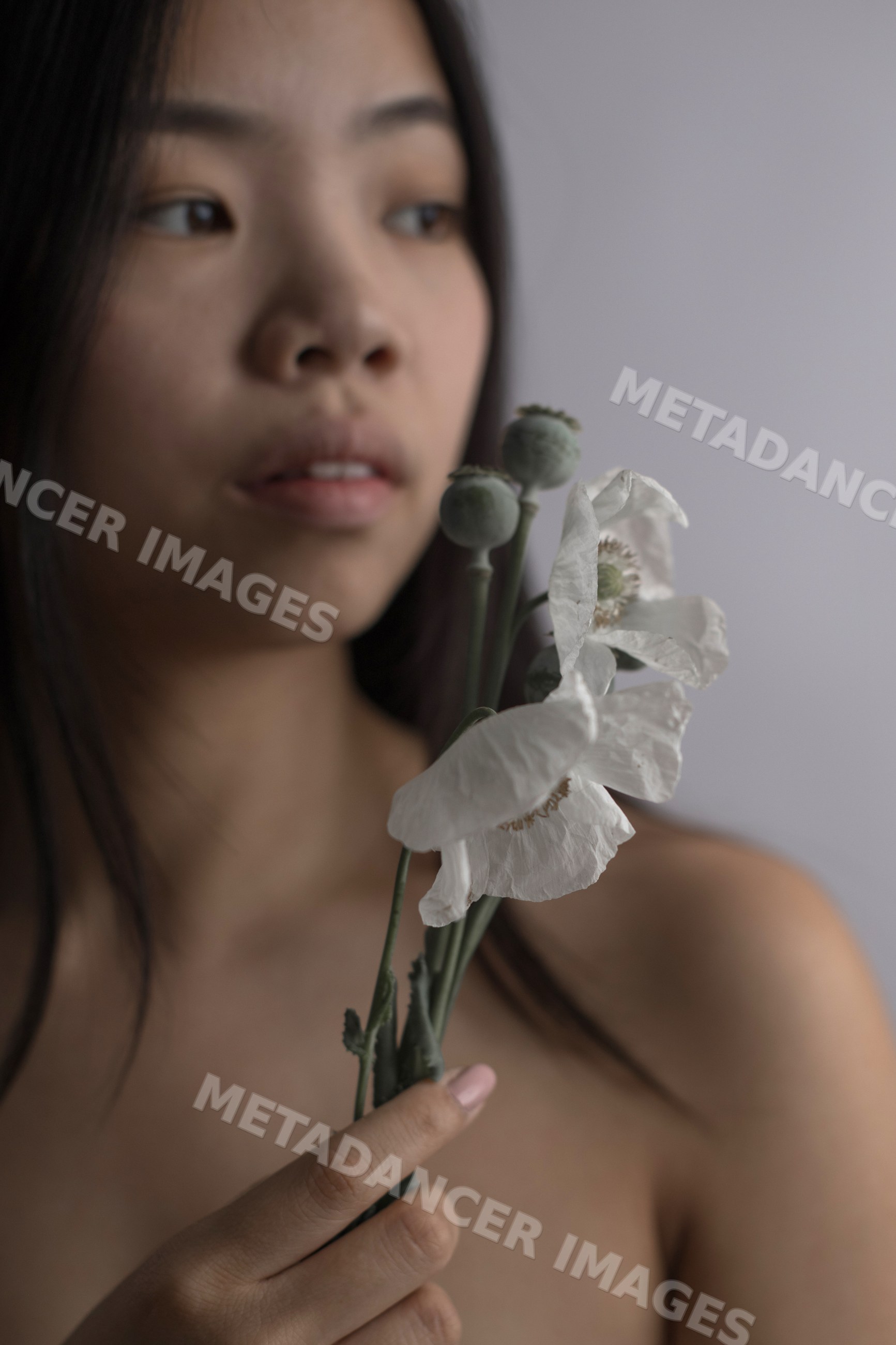 Portrait of Southeast Asian woman holding white flowers with poppy