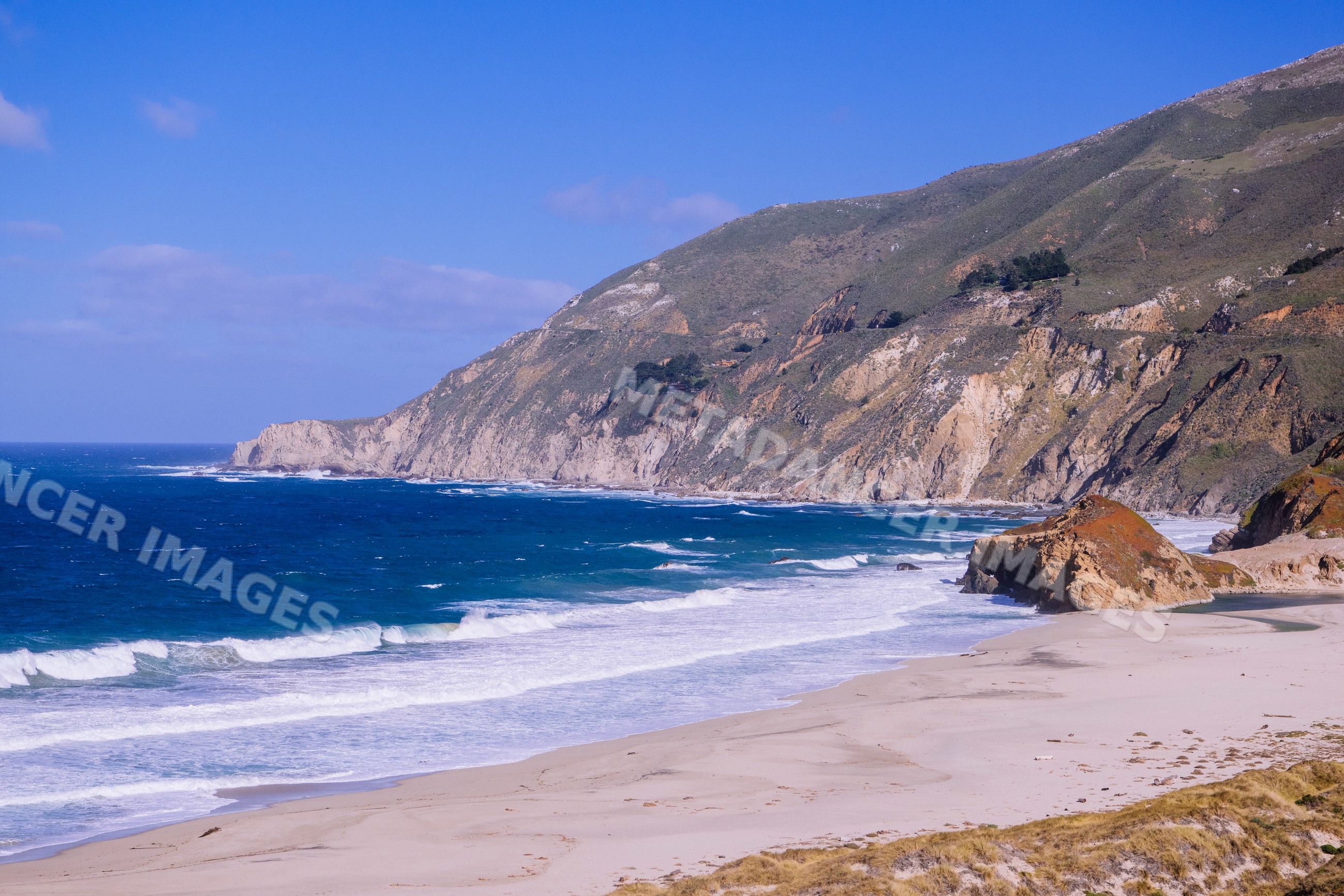California coast rocky cliffs and sandy beach with ocean waves