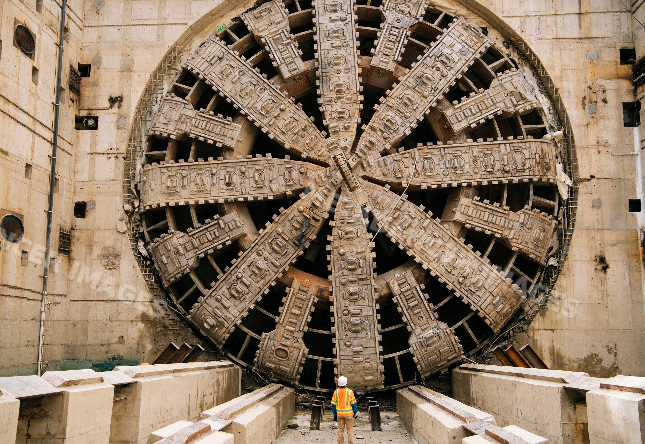 White Workers stand near a large tunnel boring machine