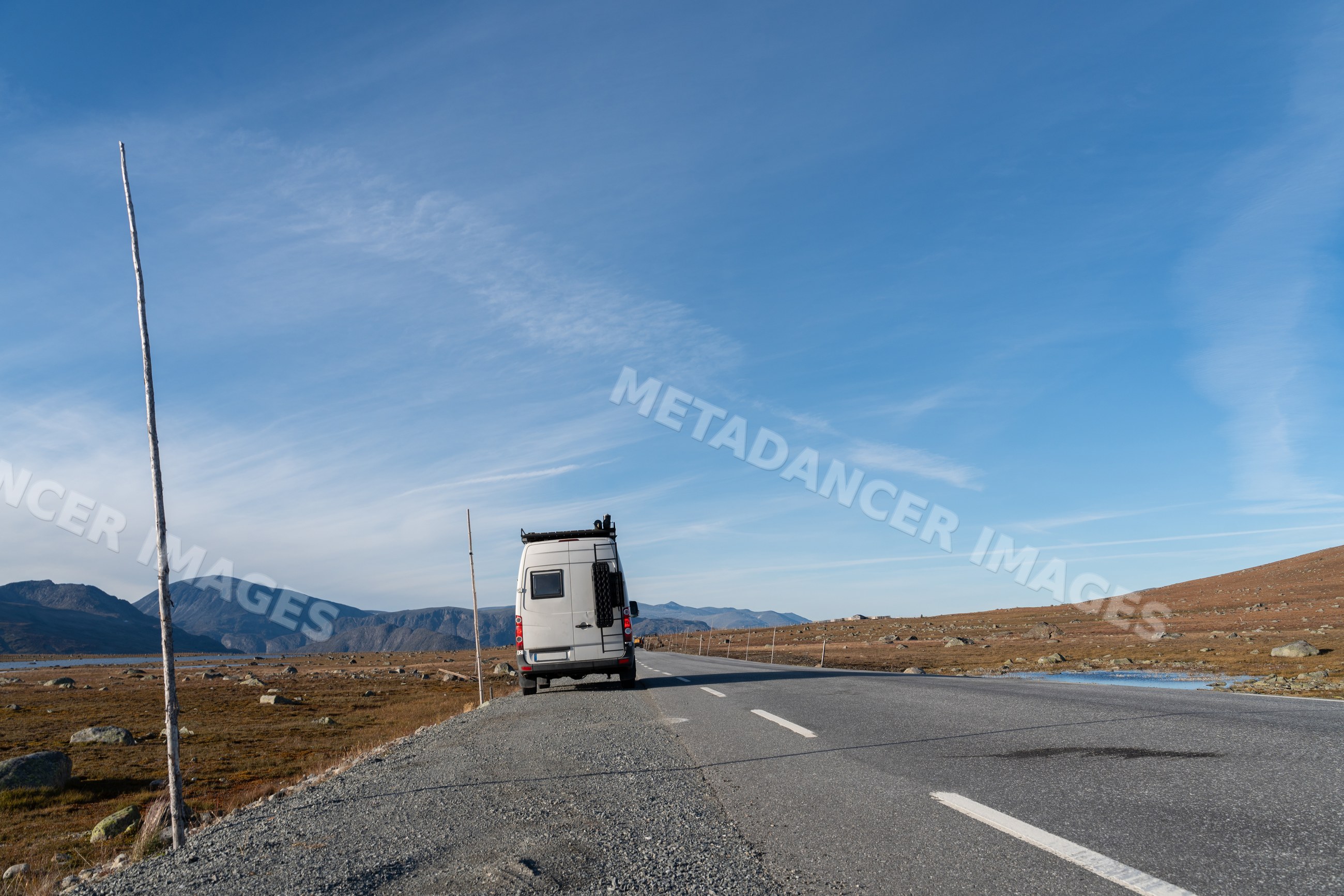 Van parked on road in mountainous landscape in Norway