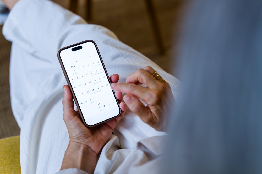 White woman using mobile phone calendar app to check dates