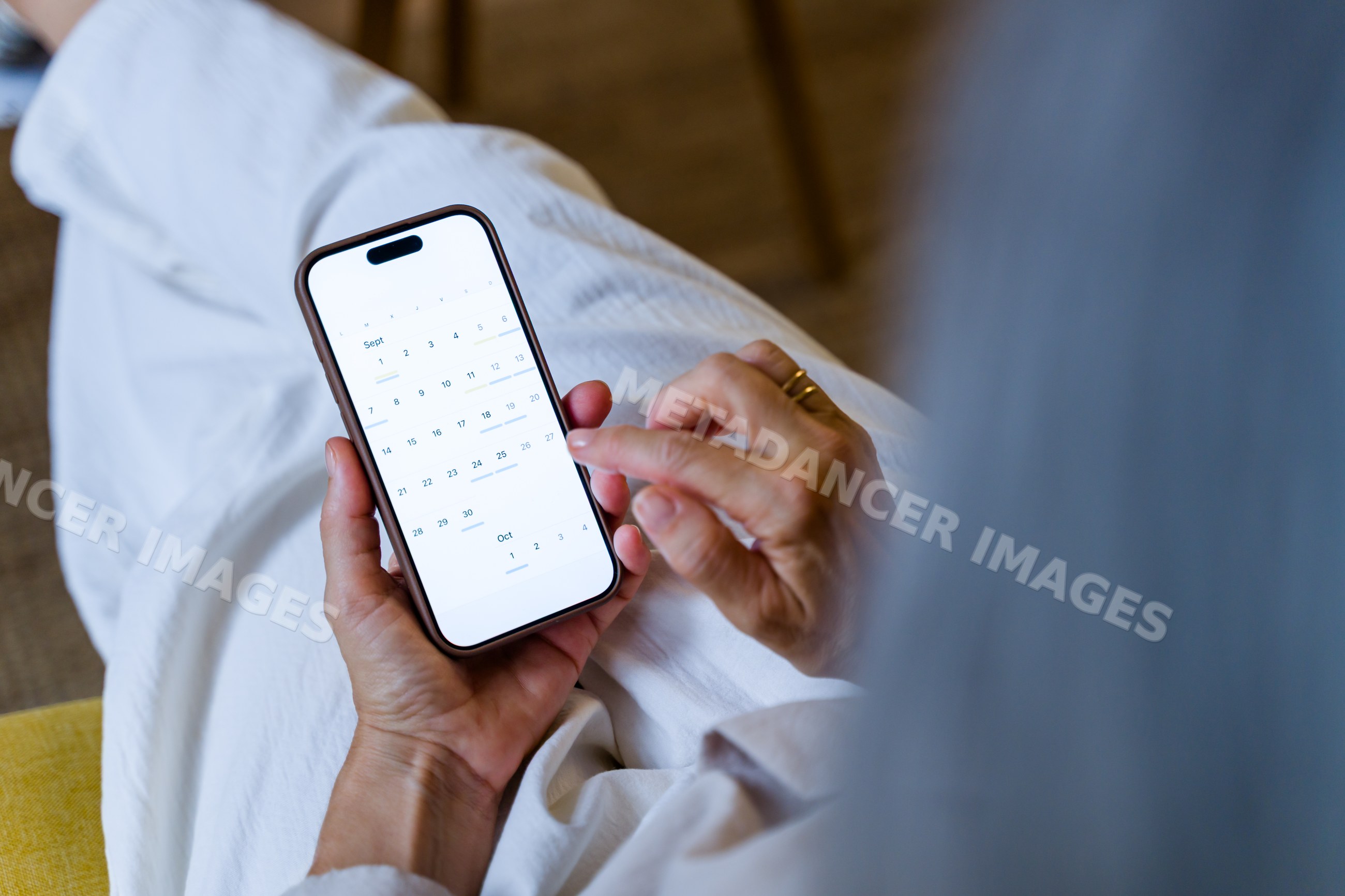 White woman using mobile phone calendar app to check dates