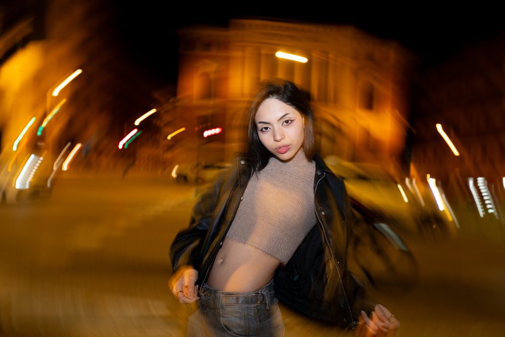 Hispanic woman posing on nighttime urban street in Madrid Spain