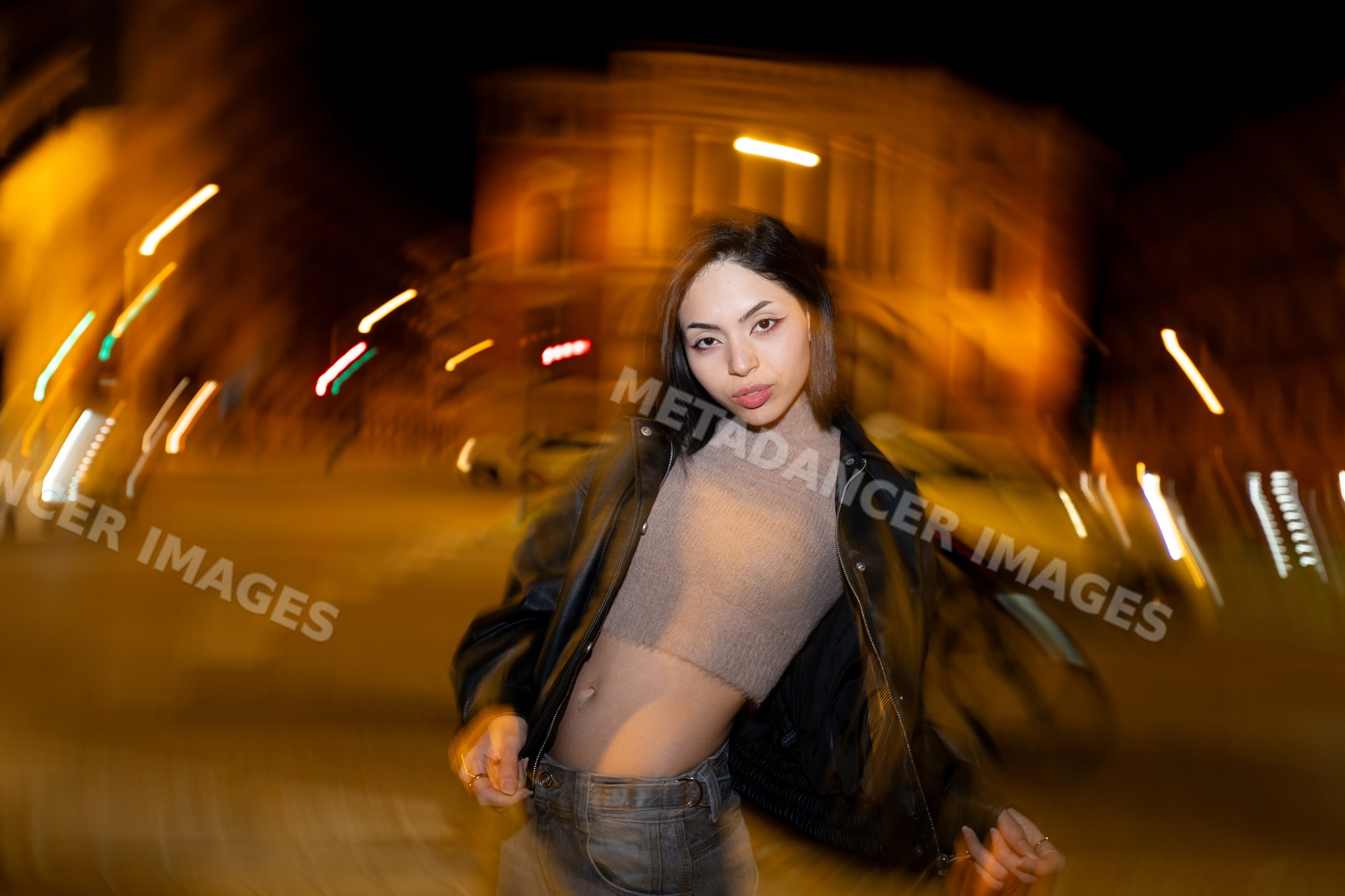 Hispanic woman posing on nighttime urban street in Madrid Spain