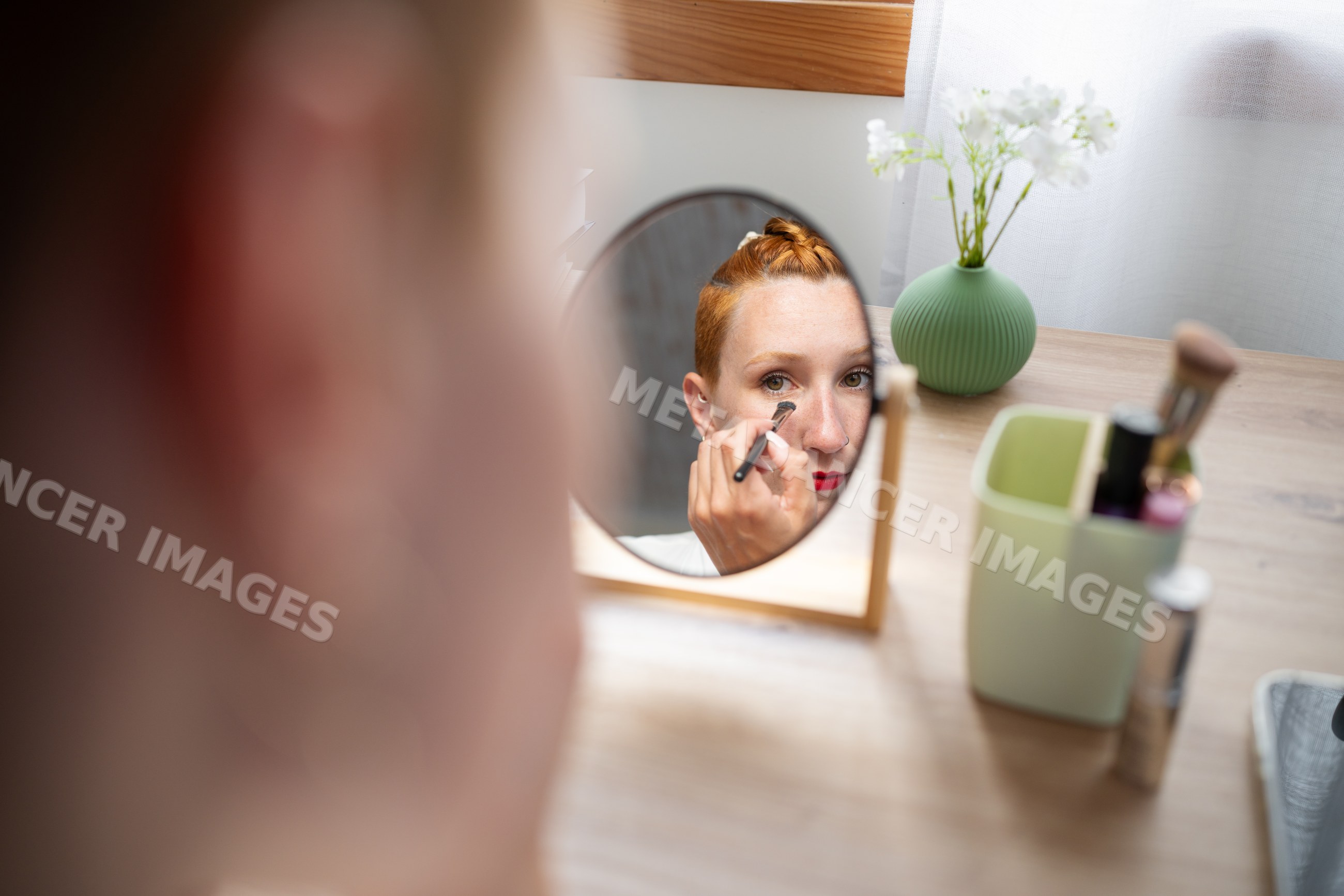 A white woman applies makeup at home in Galicia, Spain