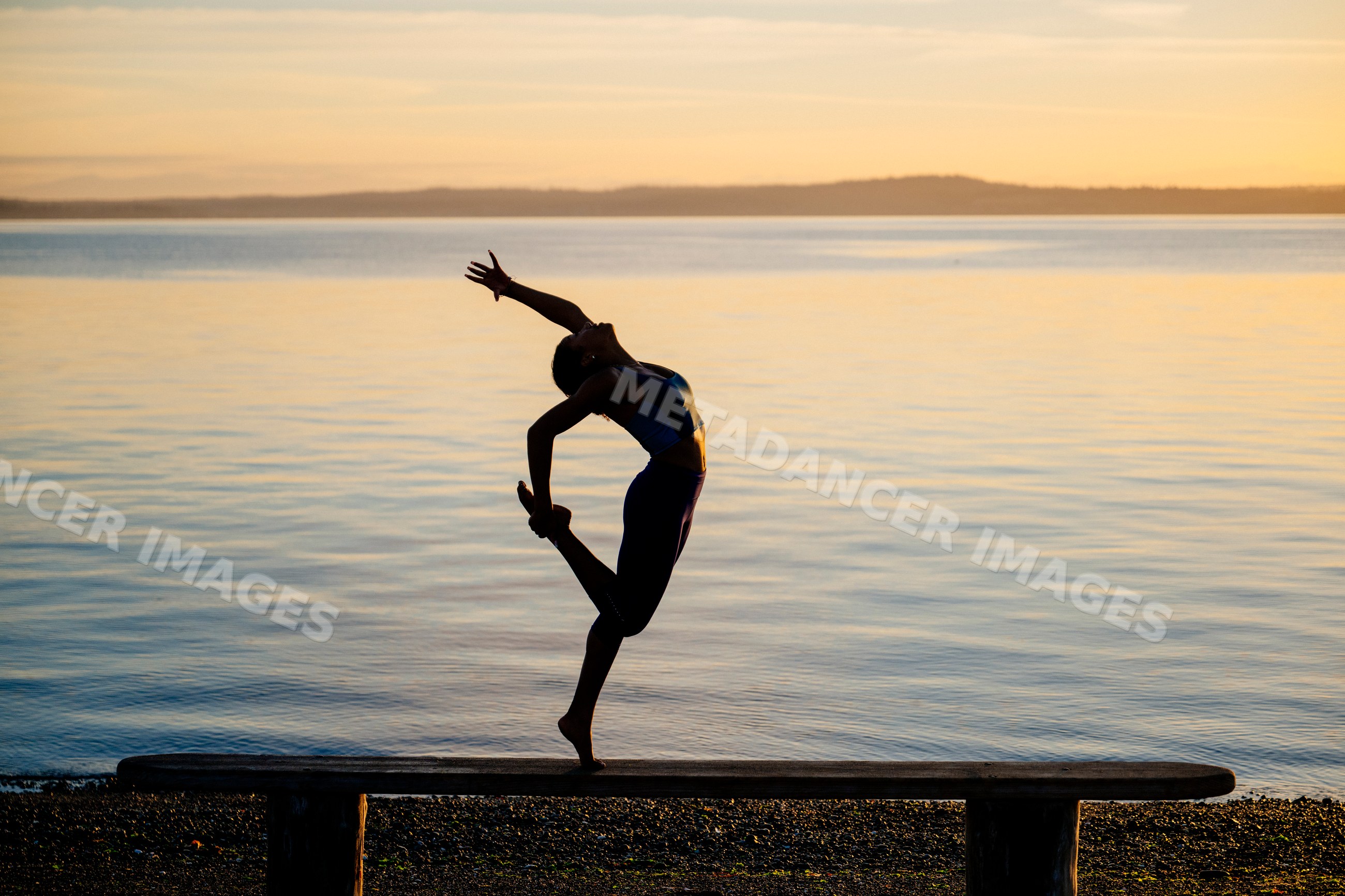 Hispanic woman practicing yoga acrobatics balancing on a bench