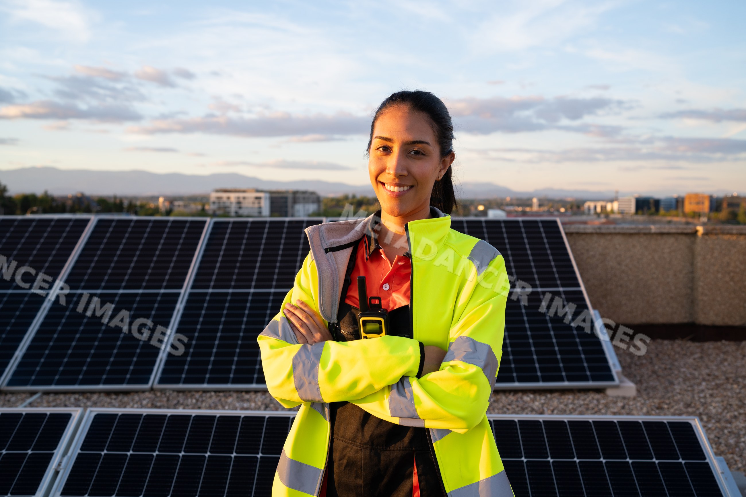 Hispanic woman engineer standing by solar panels on rooftop