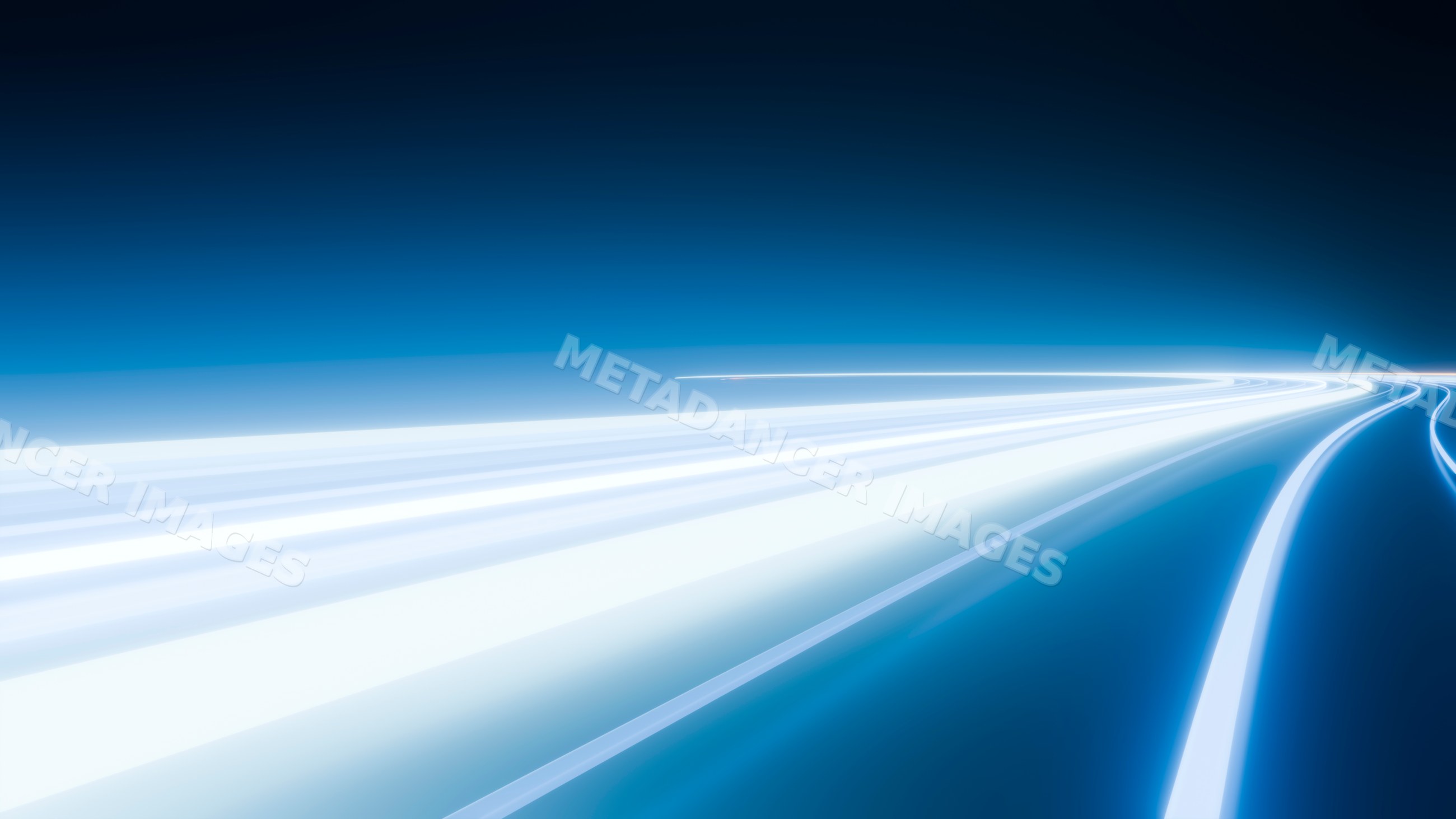 Curving light trails on highway at night showing motion and speed