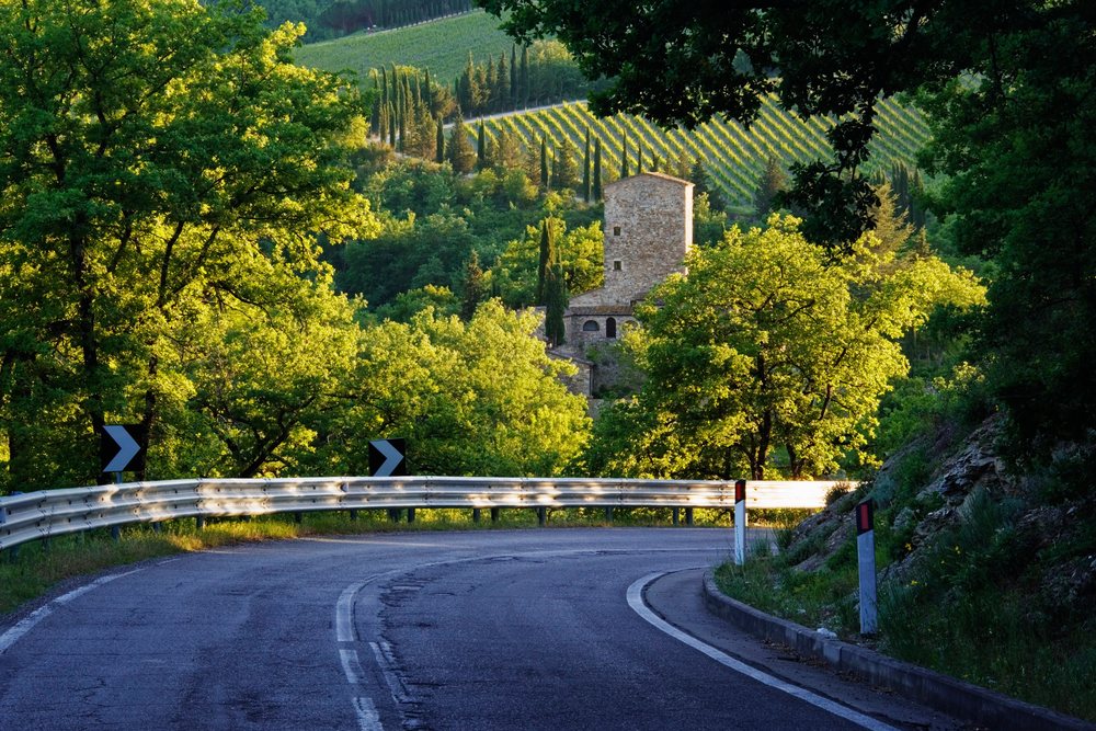 Curved rural road near stone farmhouse, italy