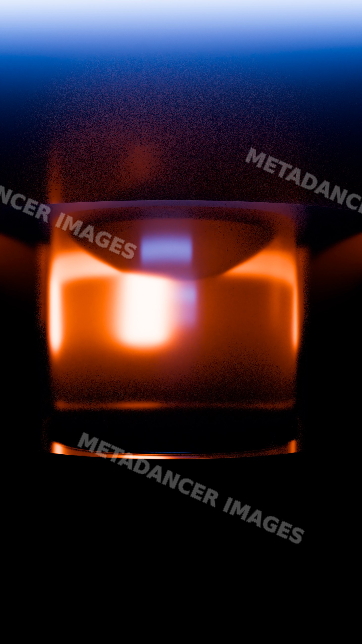 Transparent glass illuminated with warm light on dark background