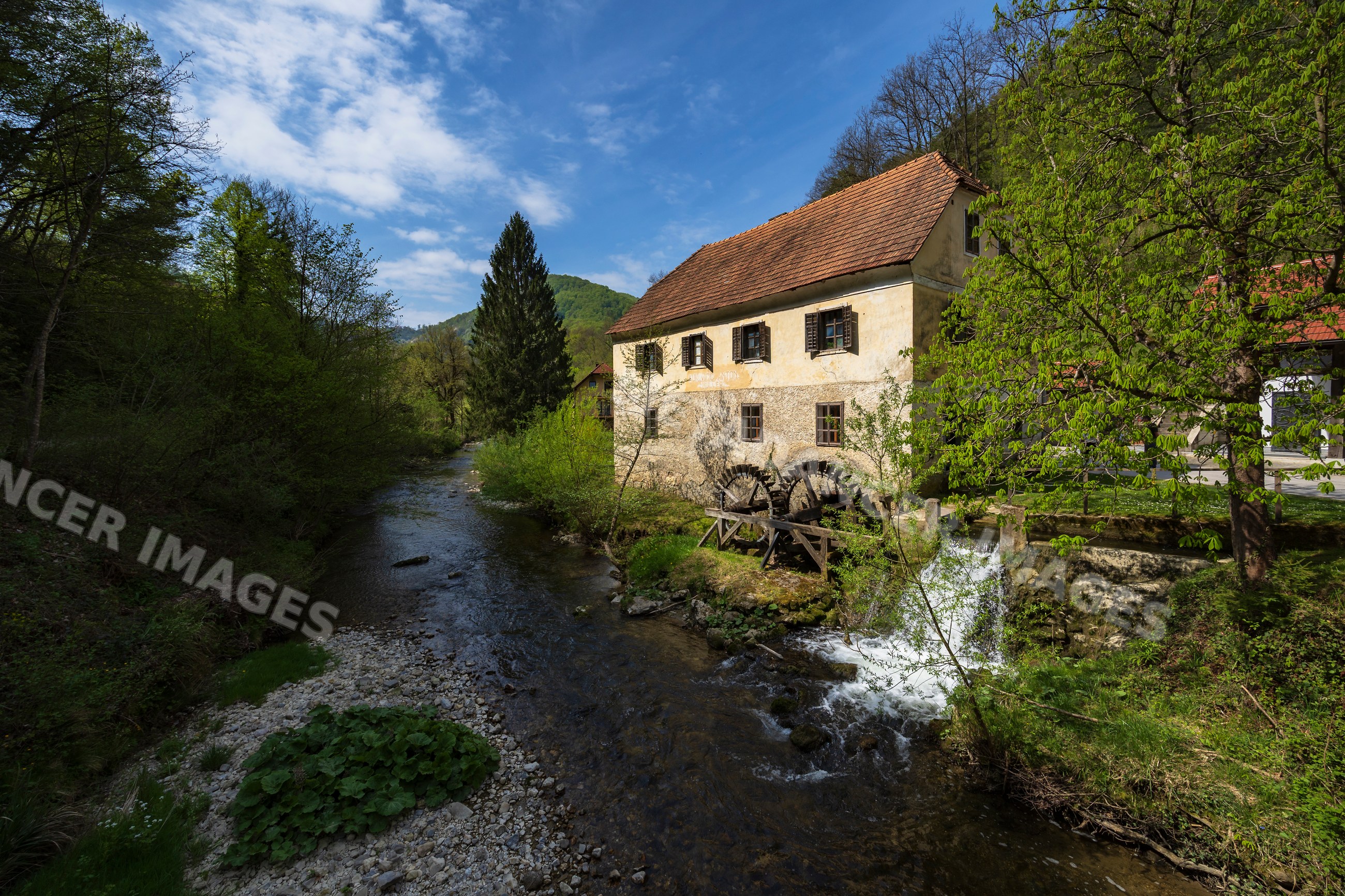 Mill with water wheel on a stream in forest near podsreda Slovenia