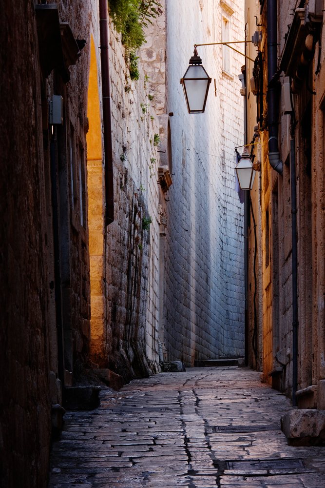 Stone alley with street lamps