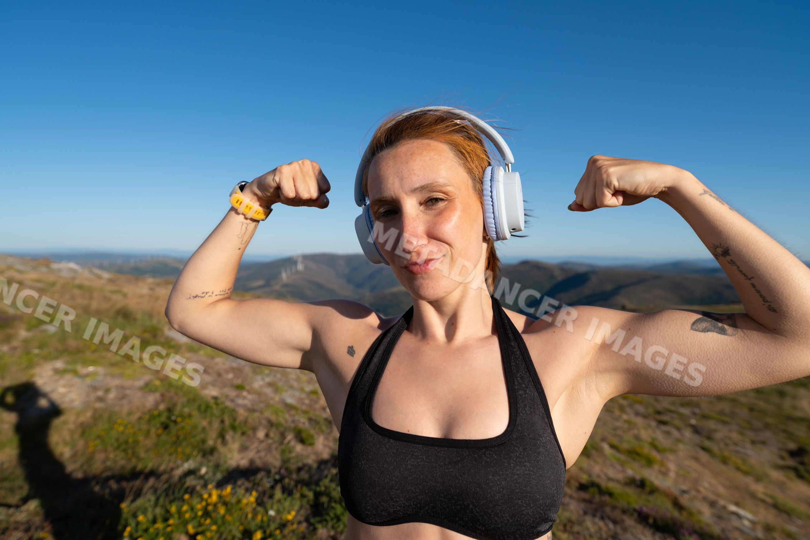 Fit white woman flexes muscles during outdoor workout in Galicia Spain