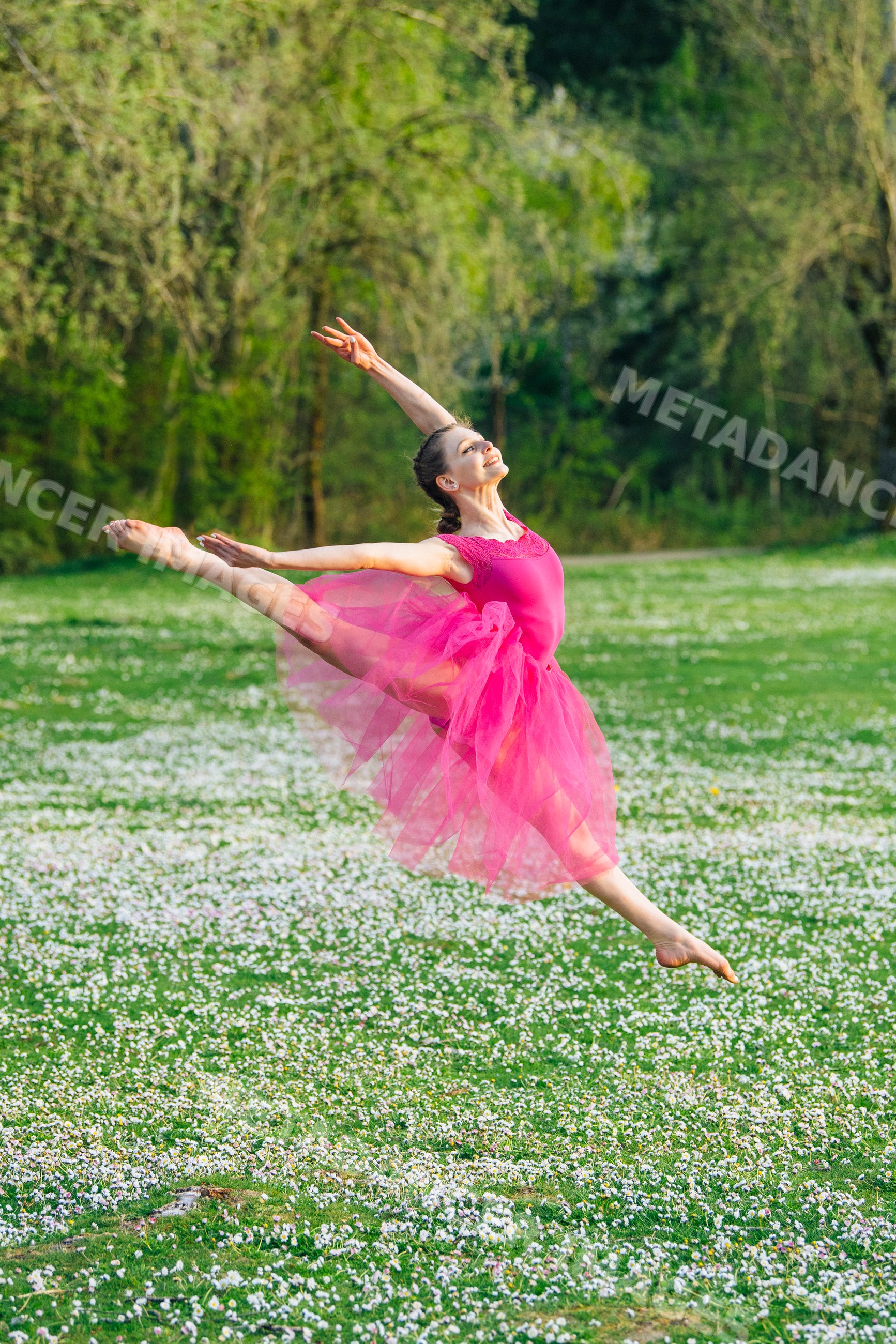 Ballet white dancer leaping gracefully in pink tutu outdoors