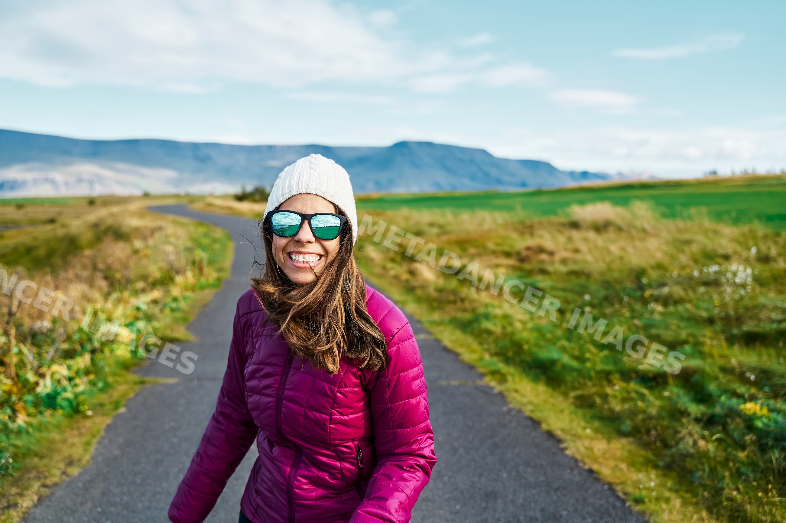 A white woman enjoys walking outdoors on a bright day