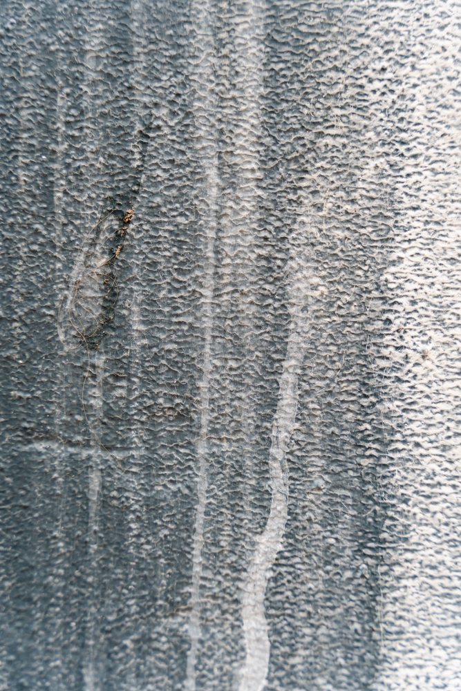 Close-up of textured weathered surface with abstract vertical streaks