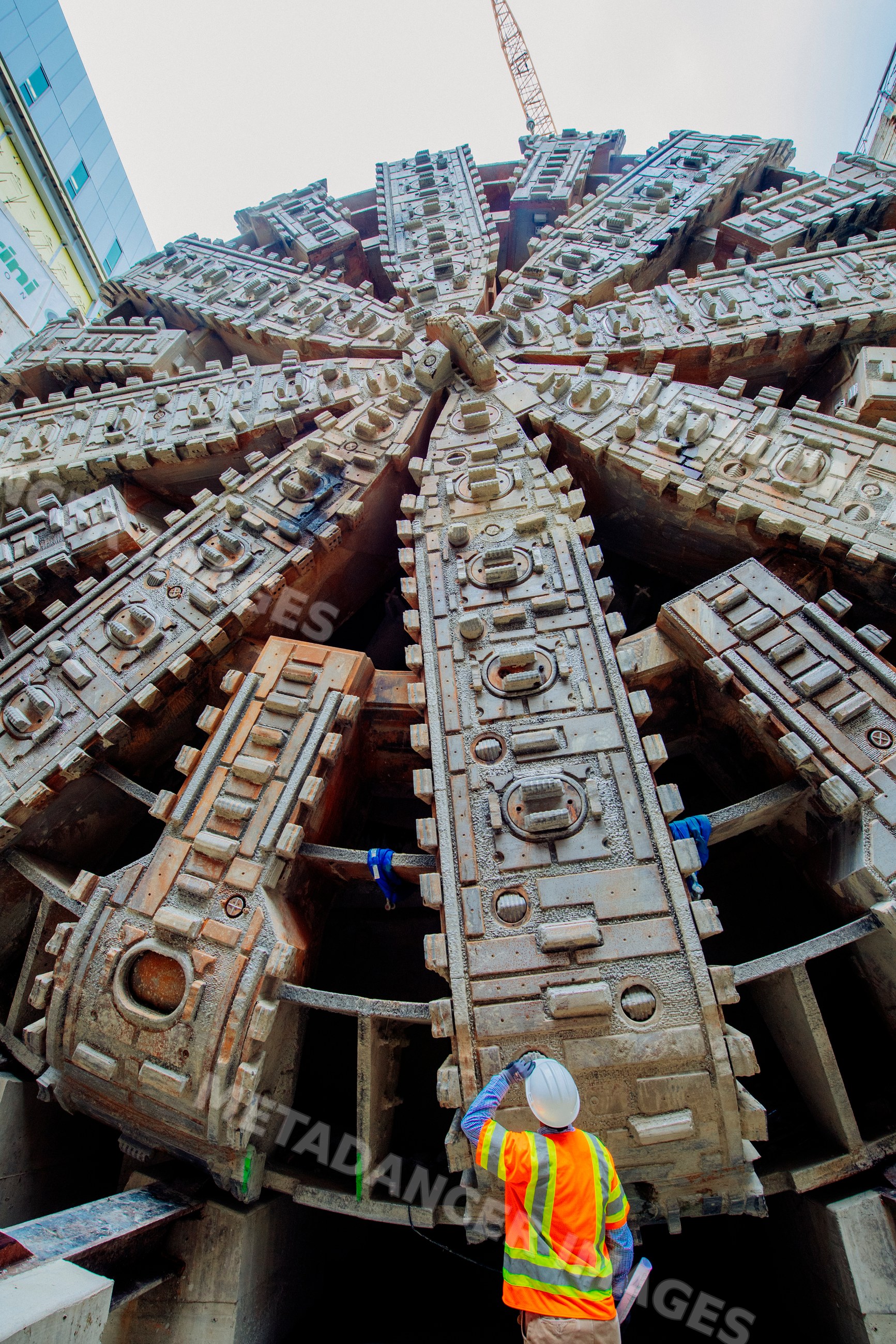 A construction white worker inspects a tunnel boring machine drilling