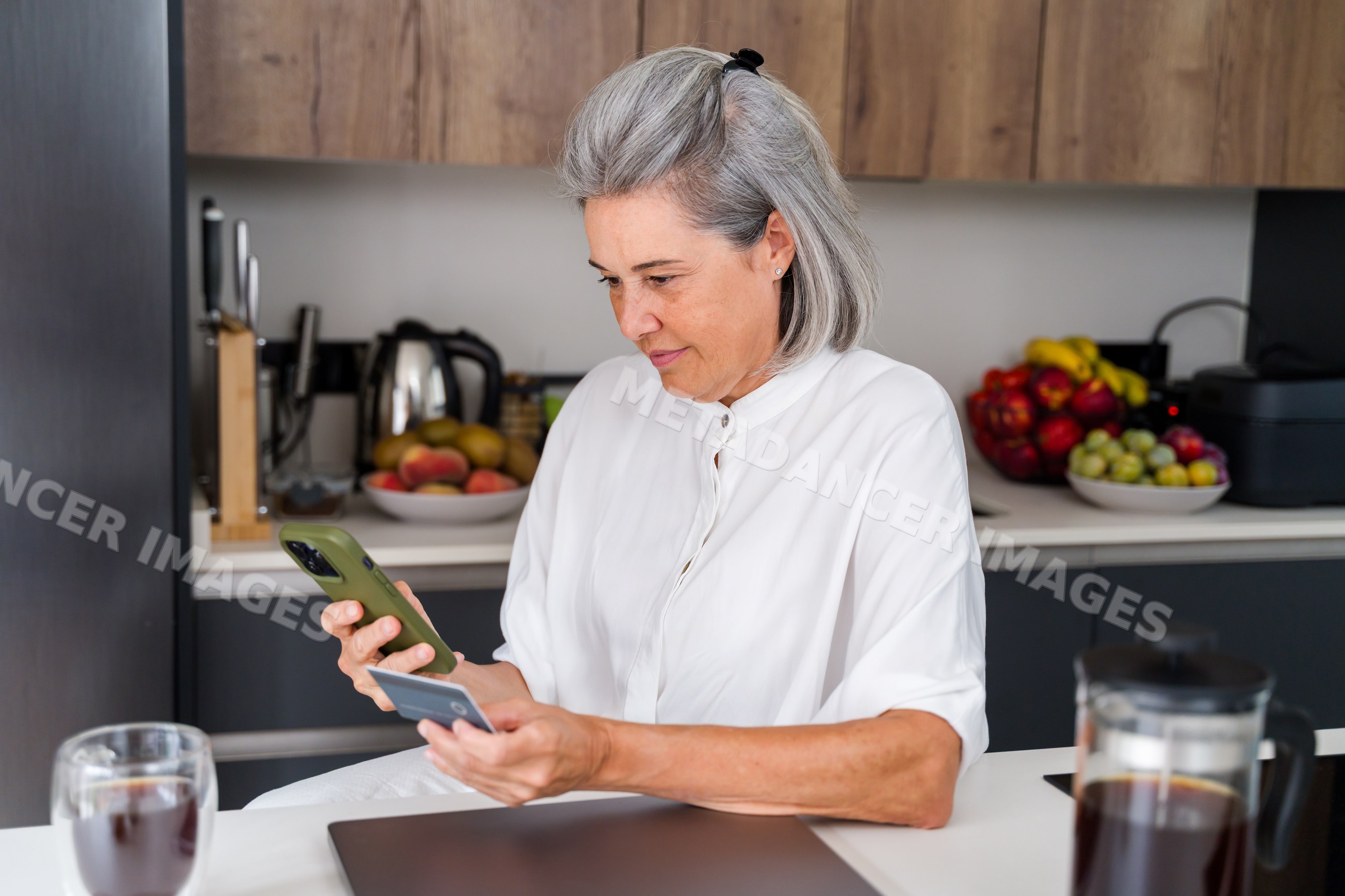 Middle-aged white woman shopping online with smartphone and card