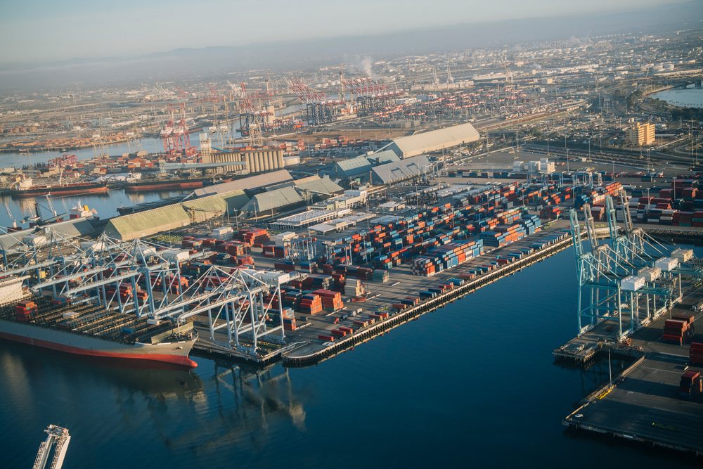 Aerial view of container port with cargo ships and cranes in a beach