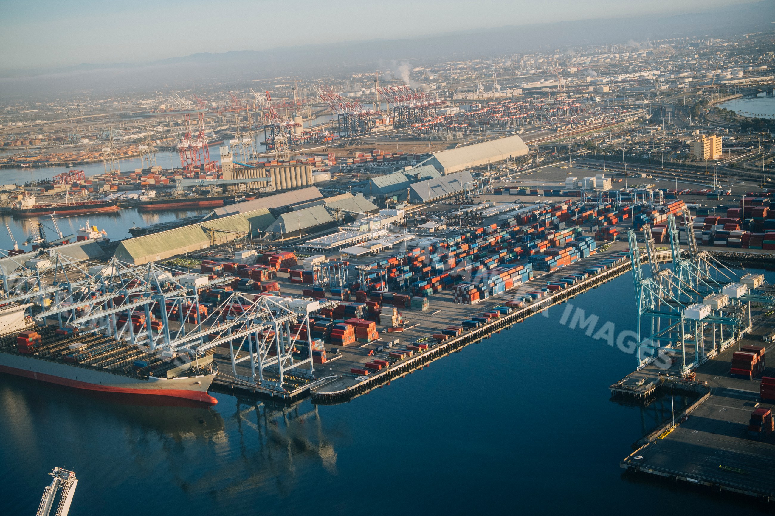 Aerial view of container port with cargo ships and cranes in a beach