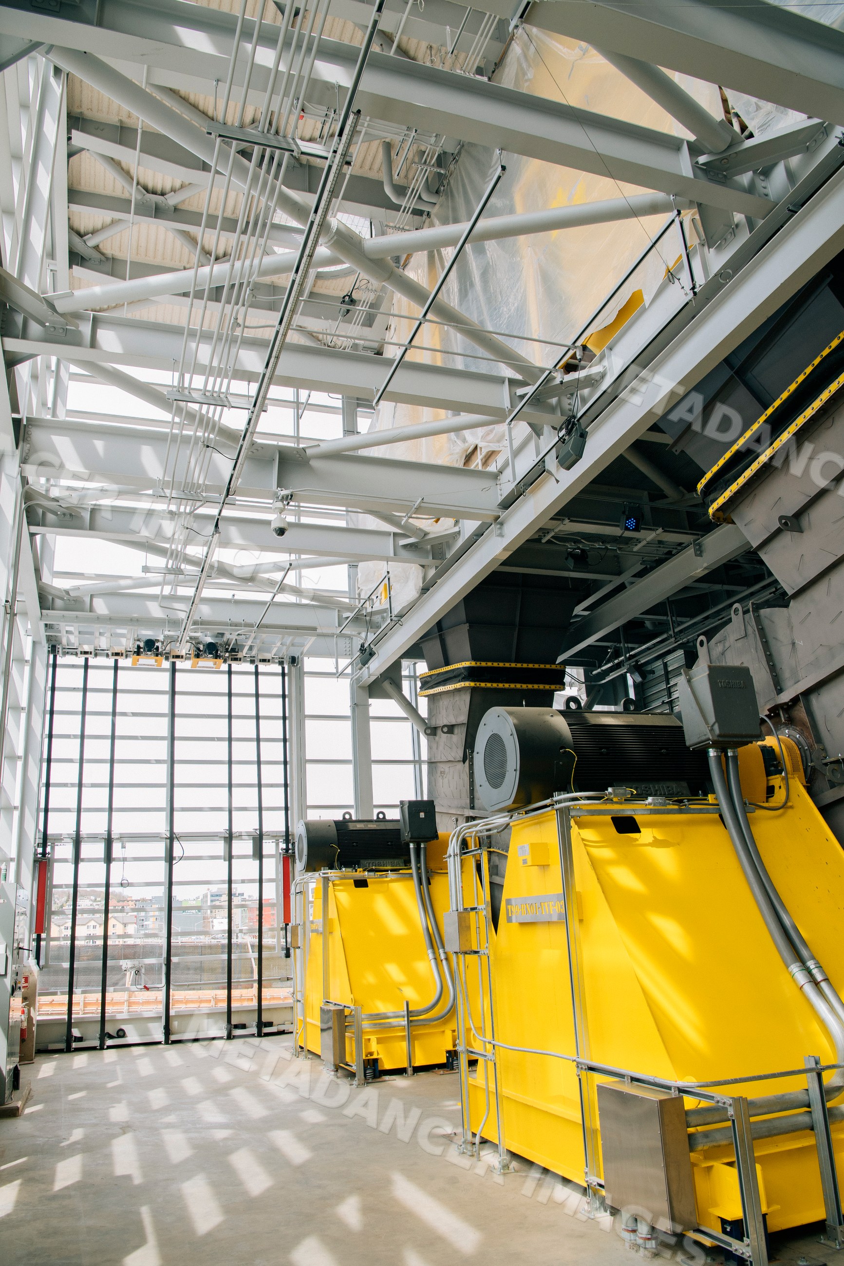 Large yellow industrial machines with electric motors inside a factory