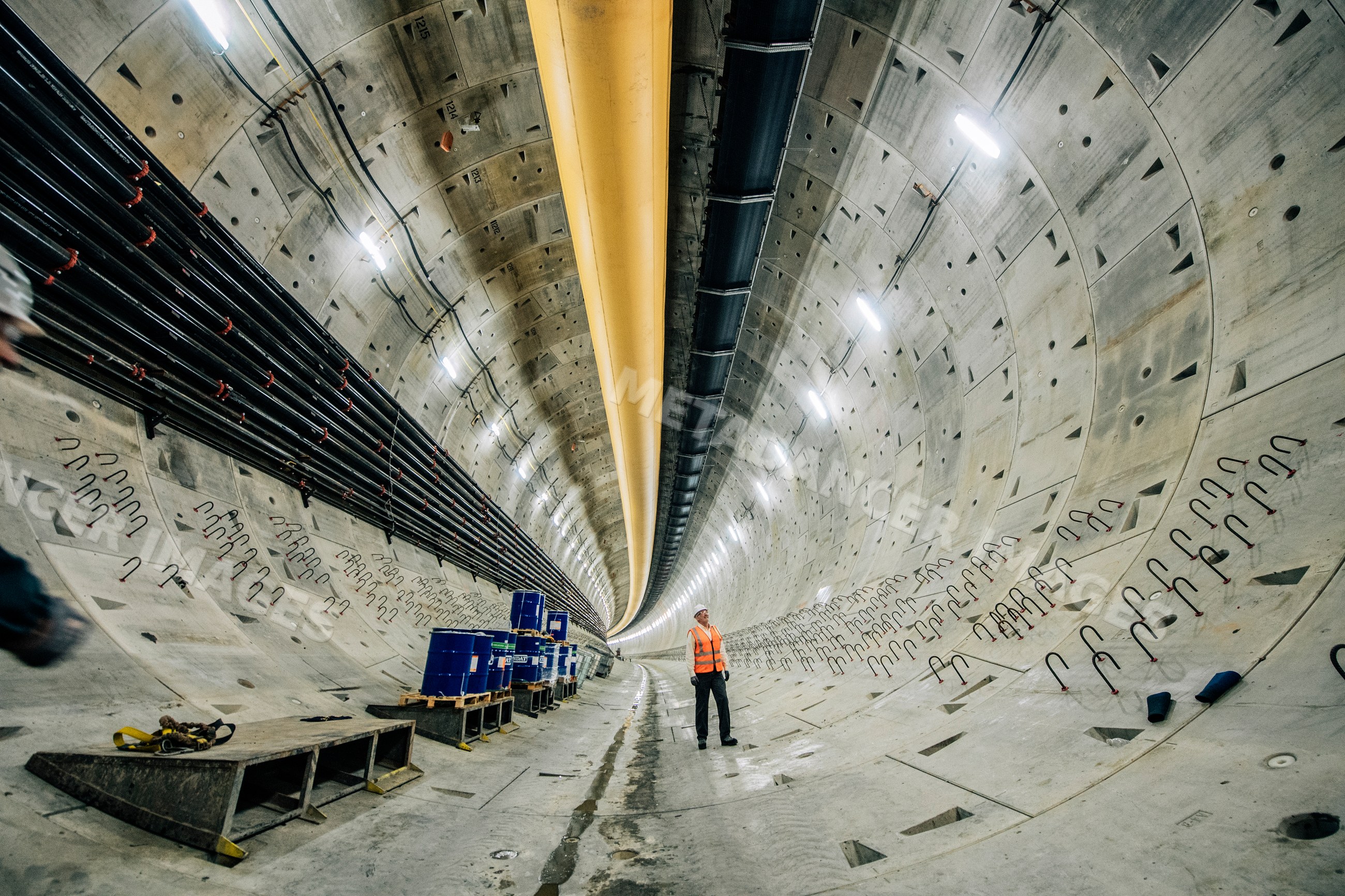 A construction white worker inspects a large underground tunnel