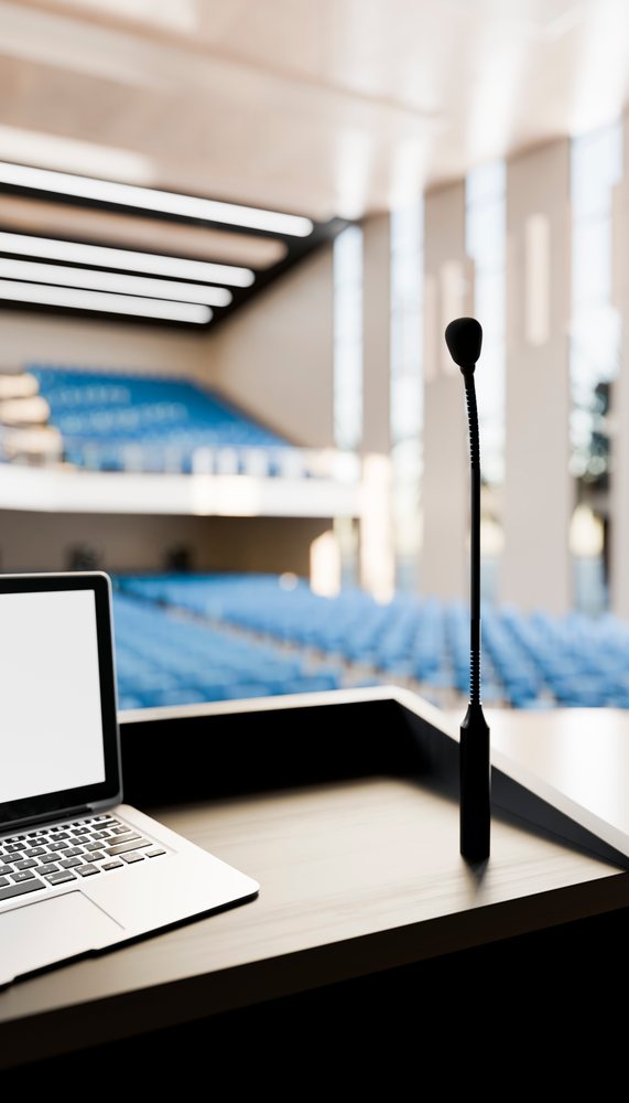 Podium microphone and laptop in modern lecture hall for presentation
