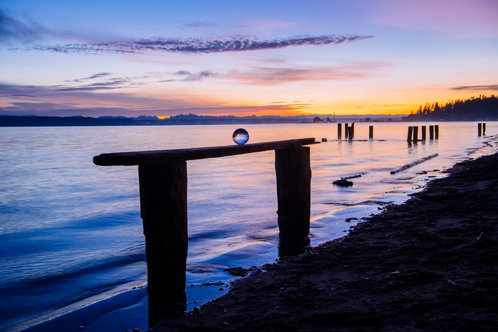 Crystal ball on wooden bench at sunset on Norwegian Point beach