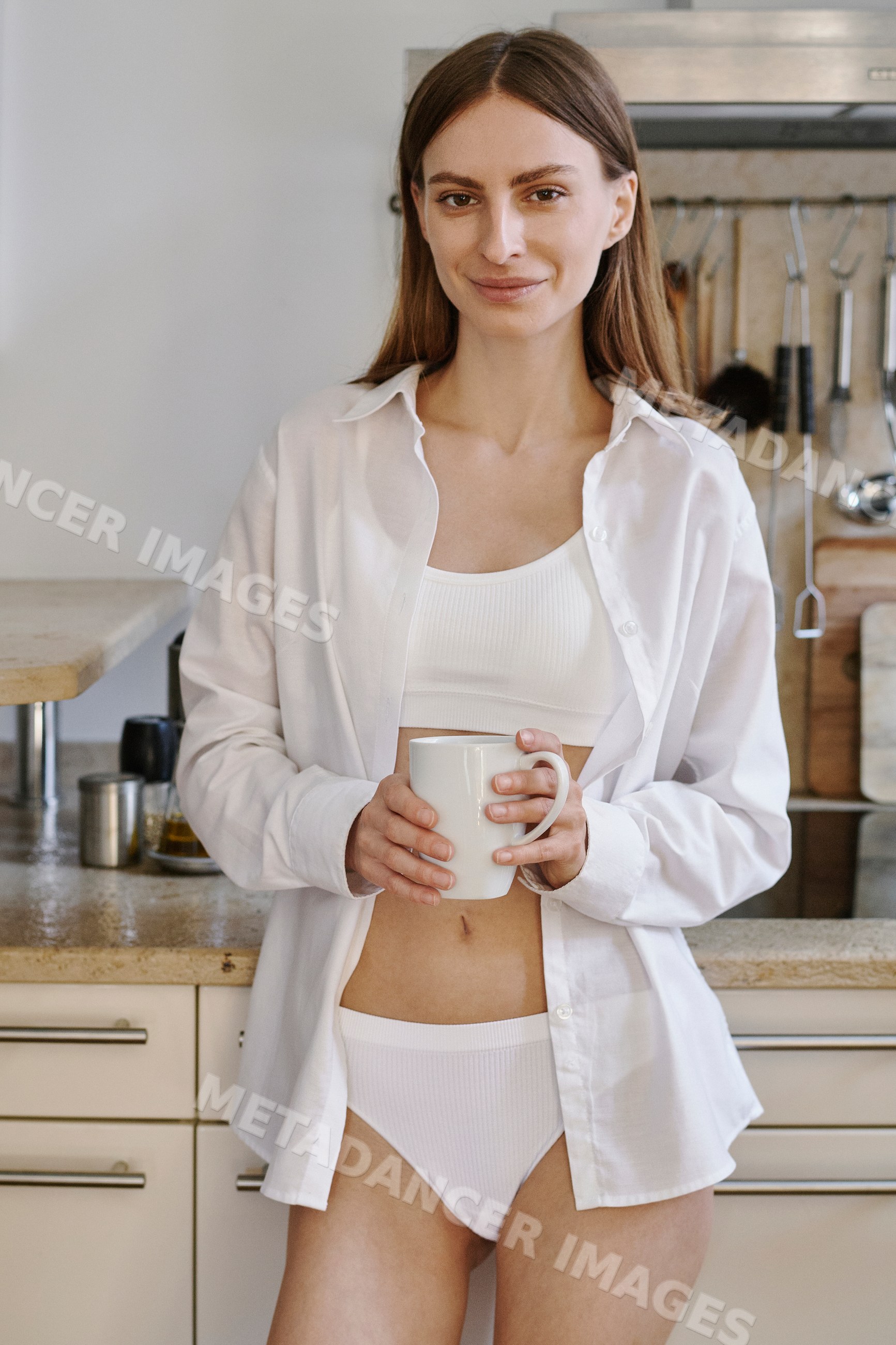 A white woman enjoying morning coffee in her kitchen in Germany