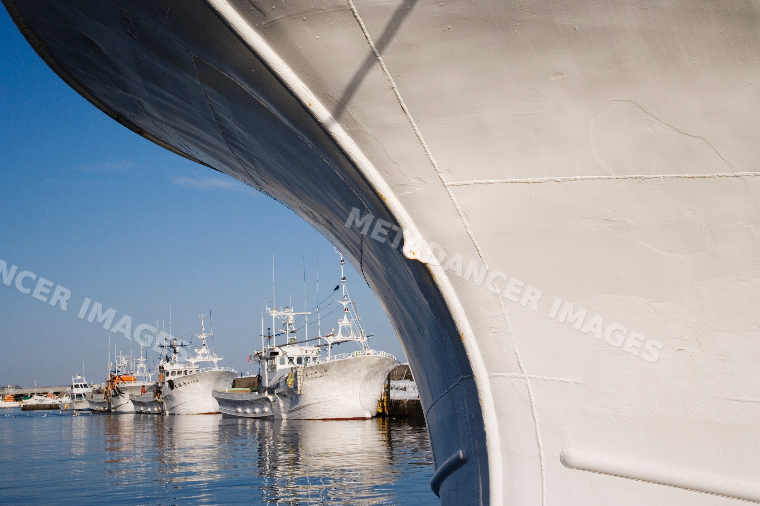 Bow of a ship with moored fishing boats in a hokkaido harbor