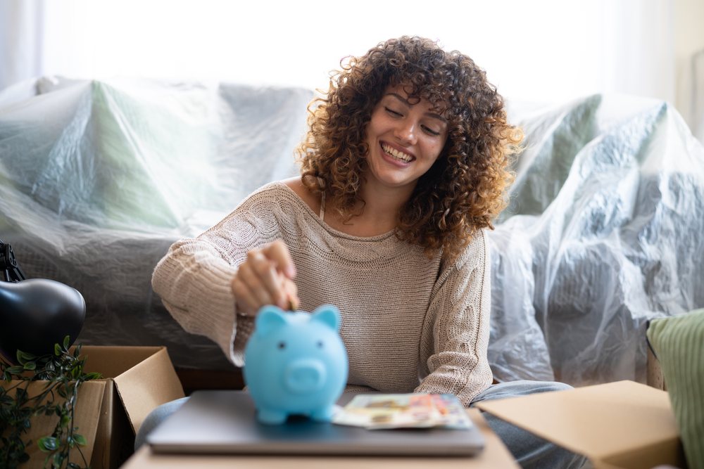 White woman saving money while moving and packing at home in Spain