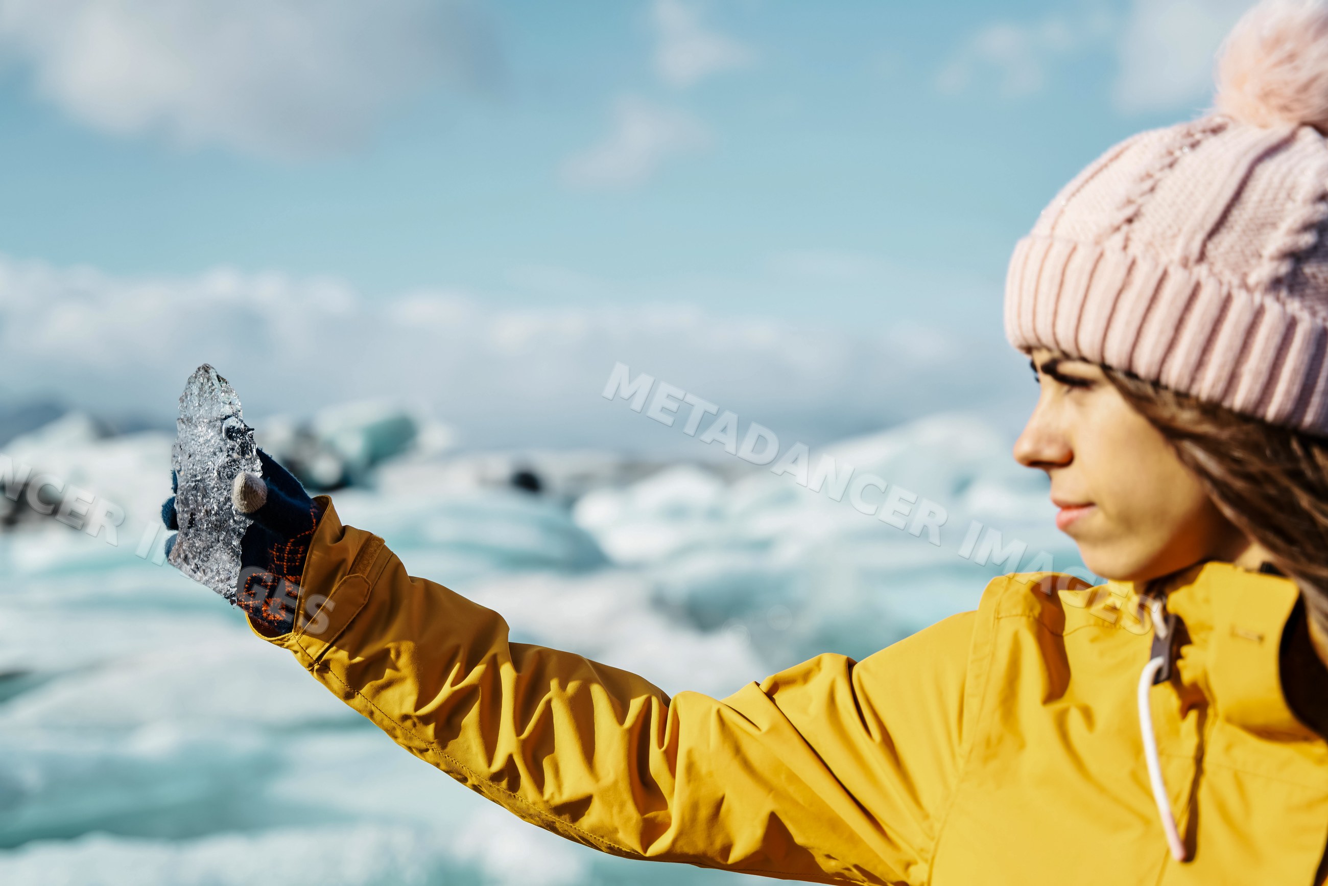 A white woman holds a piece of ice in a glacier setting