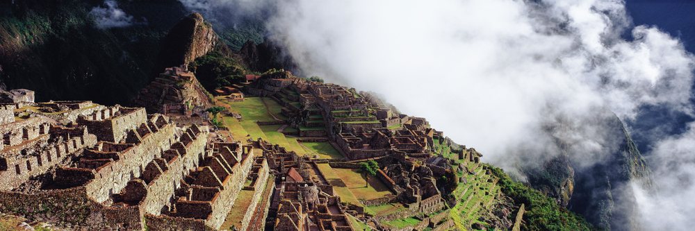 Machu picchu ruins enveloped in mist andes mountains