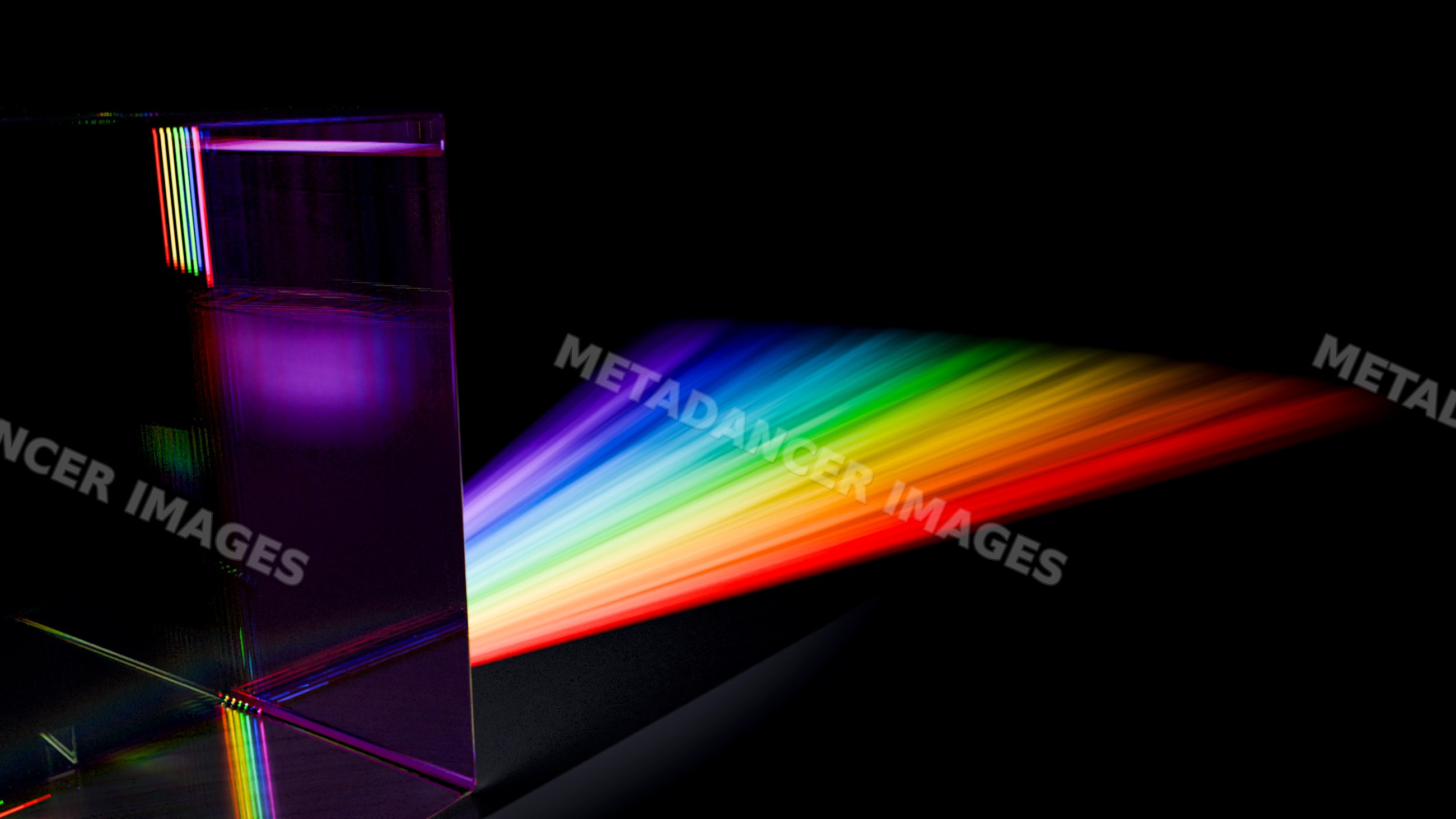Glass prism refracting white light into rainbow spectrum