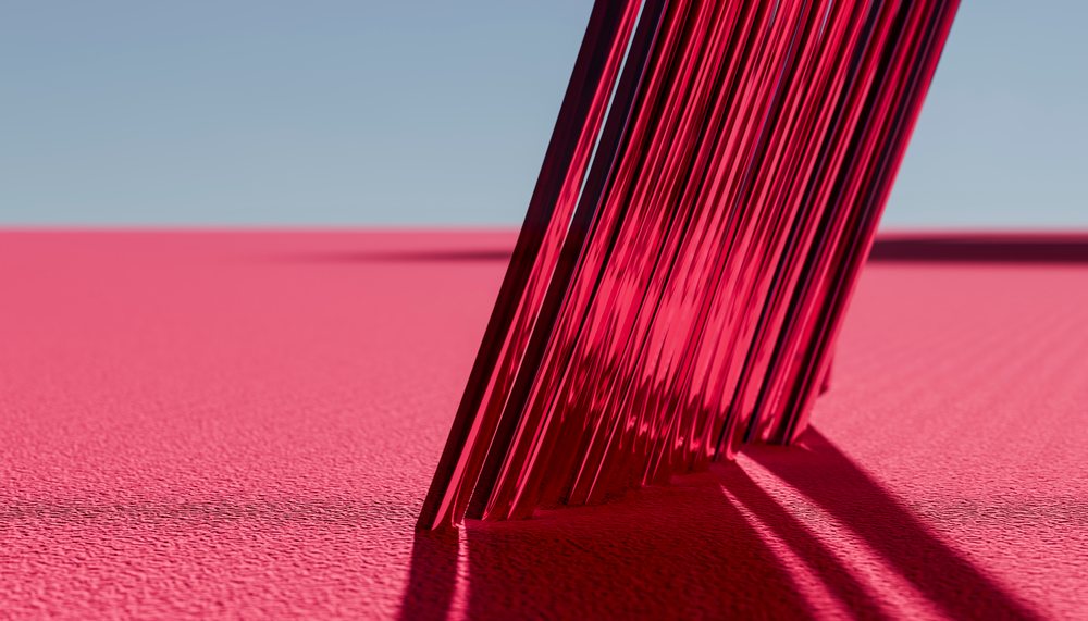 Close-up of pink metallic forks on textured surface with shadows