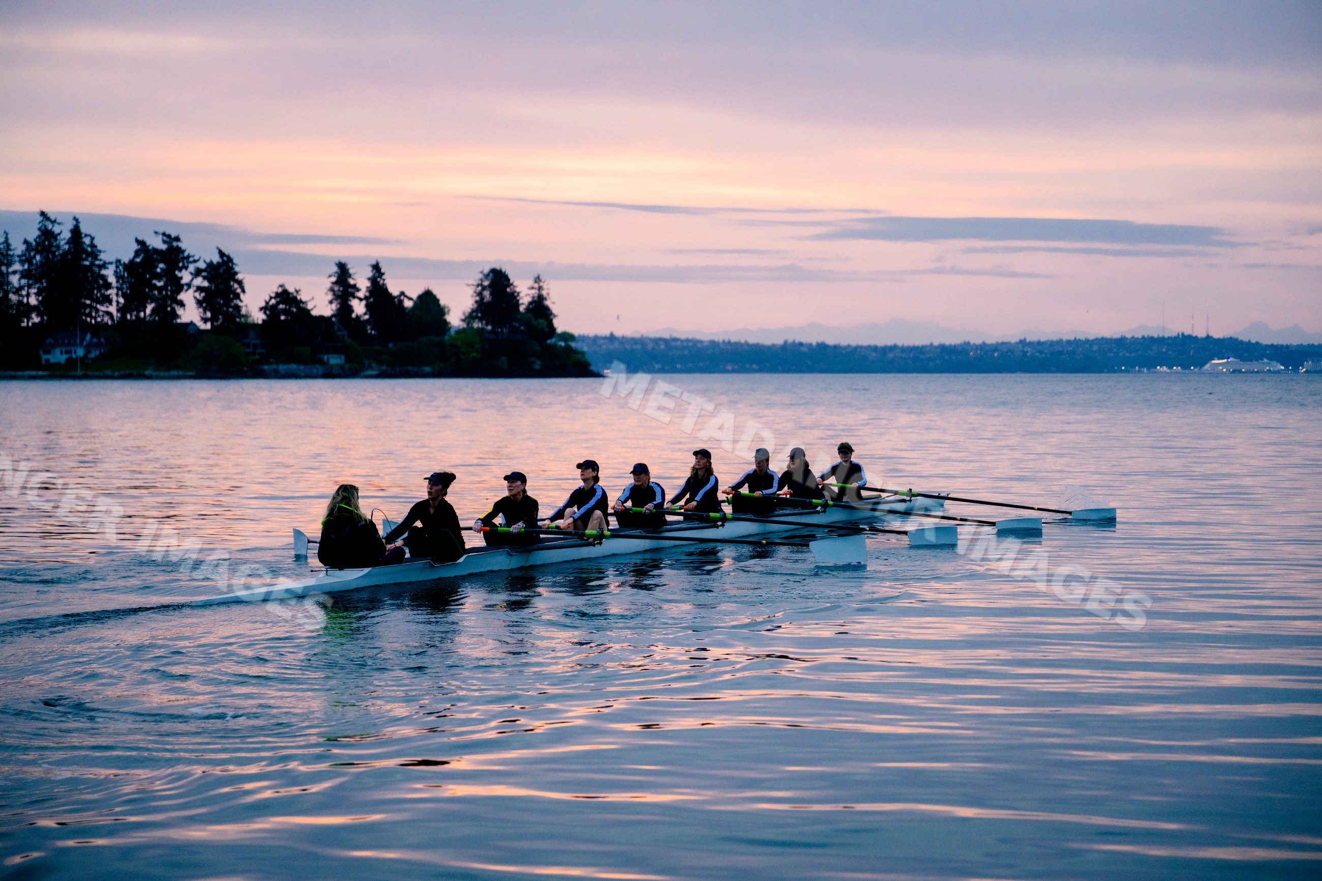 Rowing team practicing on the water at sunset in WA, USA